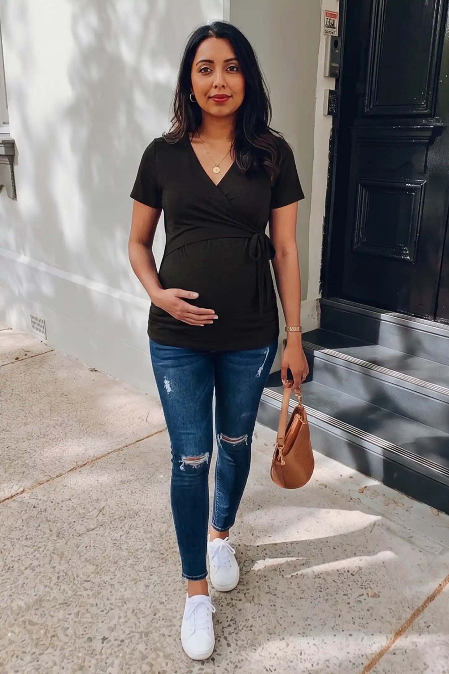 Nursing Access V-Neck Wrap Maternity & Nursing Top Nursing access V-neck wrap maternity and nursing top in black with wrap front and tie detail, front view on pregnant model
