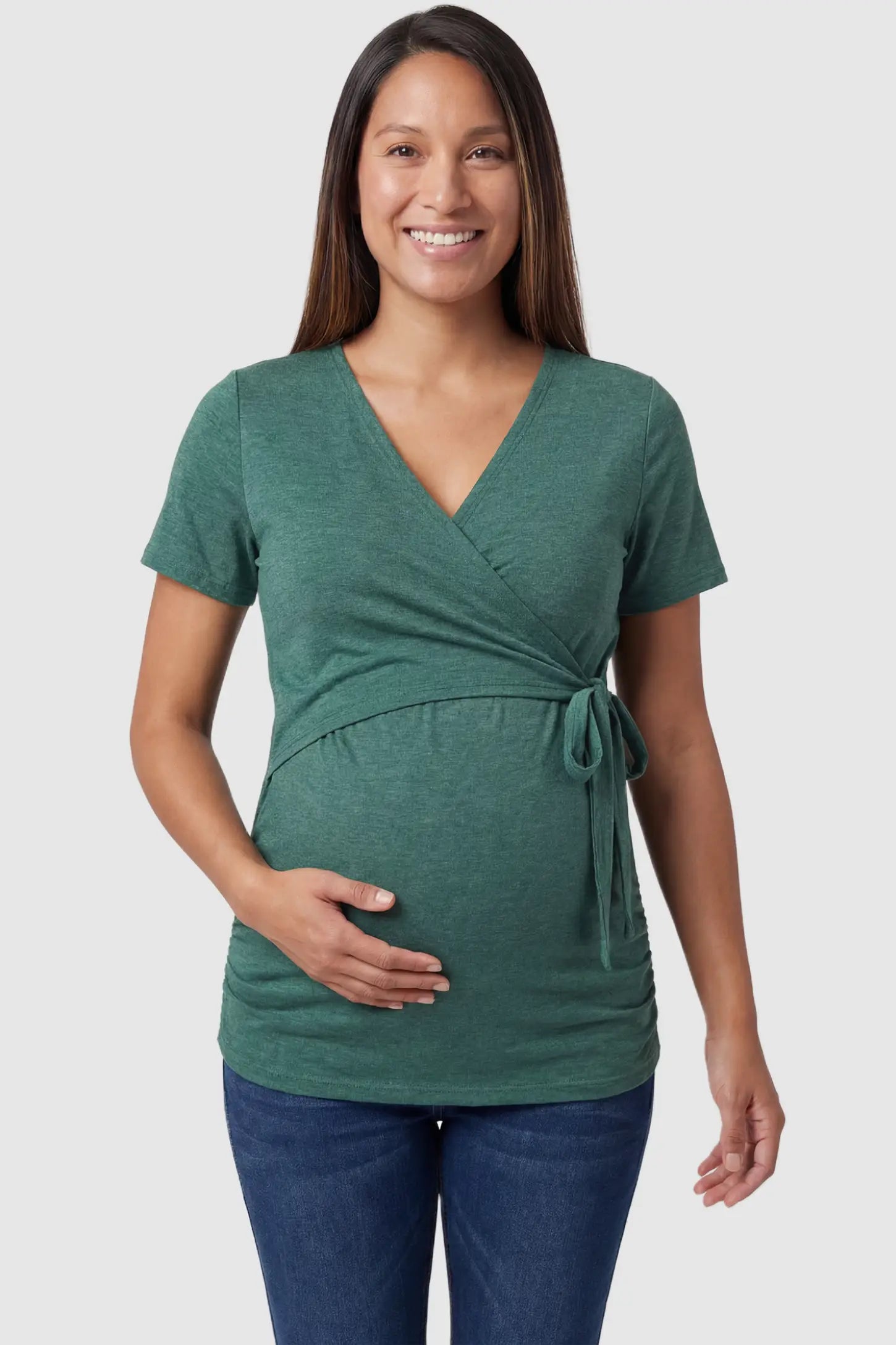 Nursing Access V-Neck Wrap Maternity & Nursing Top Nursing access V-neck wrap maternity and nursing top in green with wrap front and tie detail, front view on pregnant model