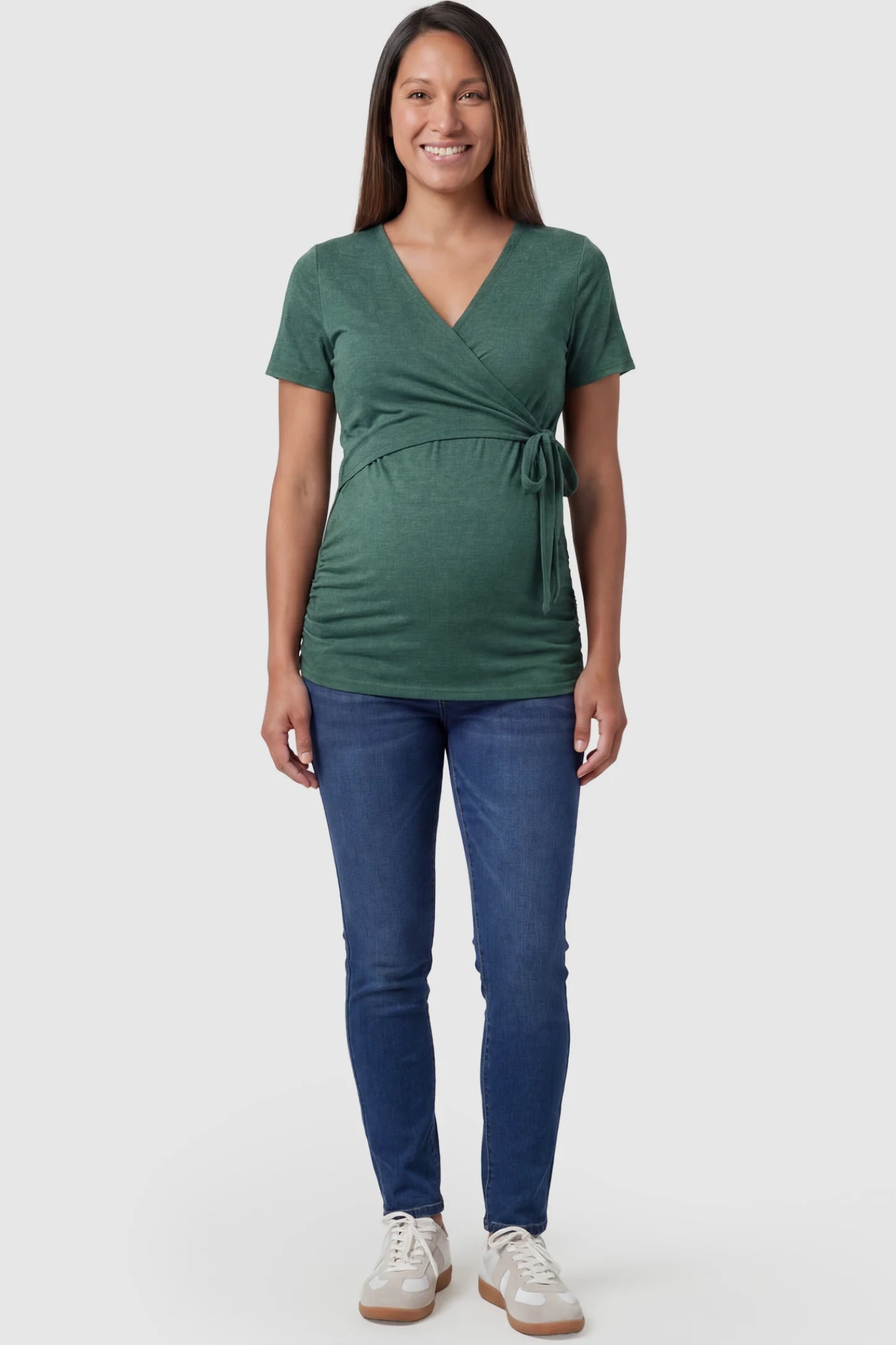 Nursing Access V-Neck Wrap Maternity & Nursing Top Nursing access V-neck wrap maternity and nursing top in green with wrap front and tie detail, front view on pregnant model