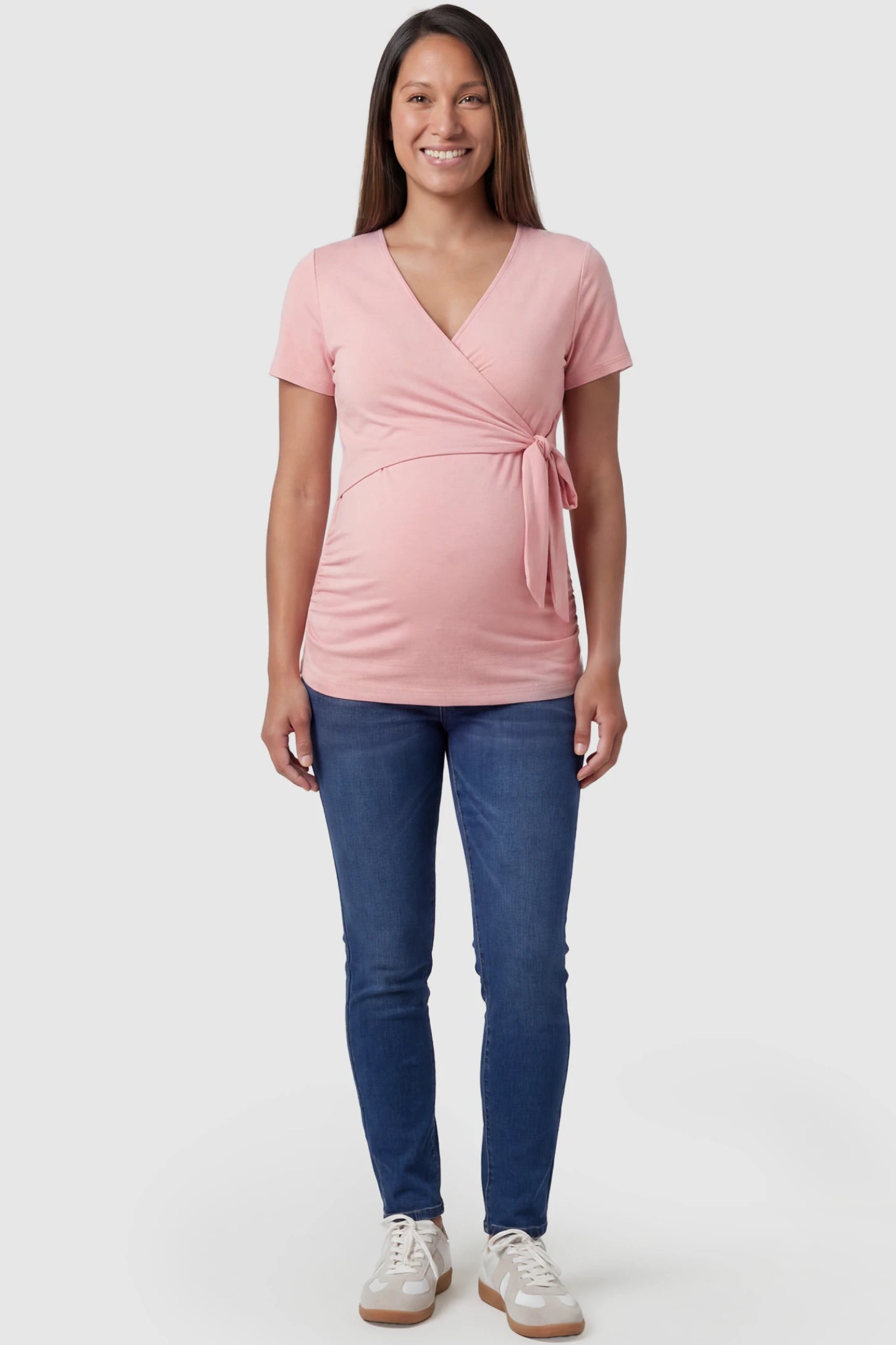Nursing Access V-Neck Wrap Maternity & Nursing Top Nursing access V-neck wrap maternity and nursing top in pink with wrap front and tie detail, front view on pregnant model