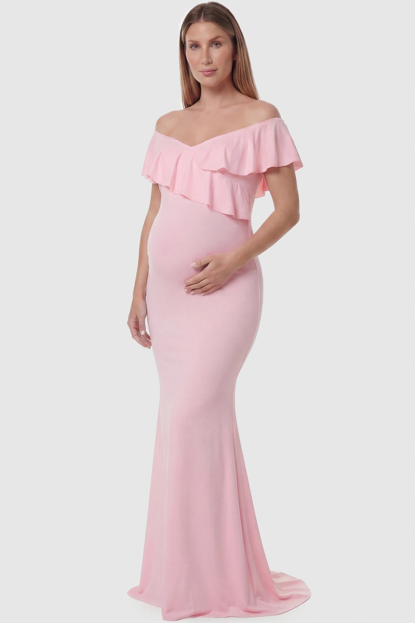 Ruffle Off-Shoulder Slim Fit Maxi Maternity Dress Ruffle off-shoulder slim fit maxi maternity dress in pink featuring elegant ruffle detailing in front view on a pregnant model