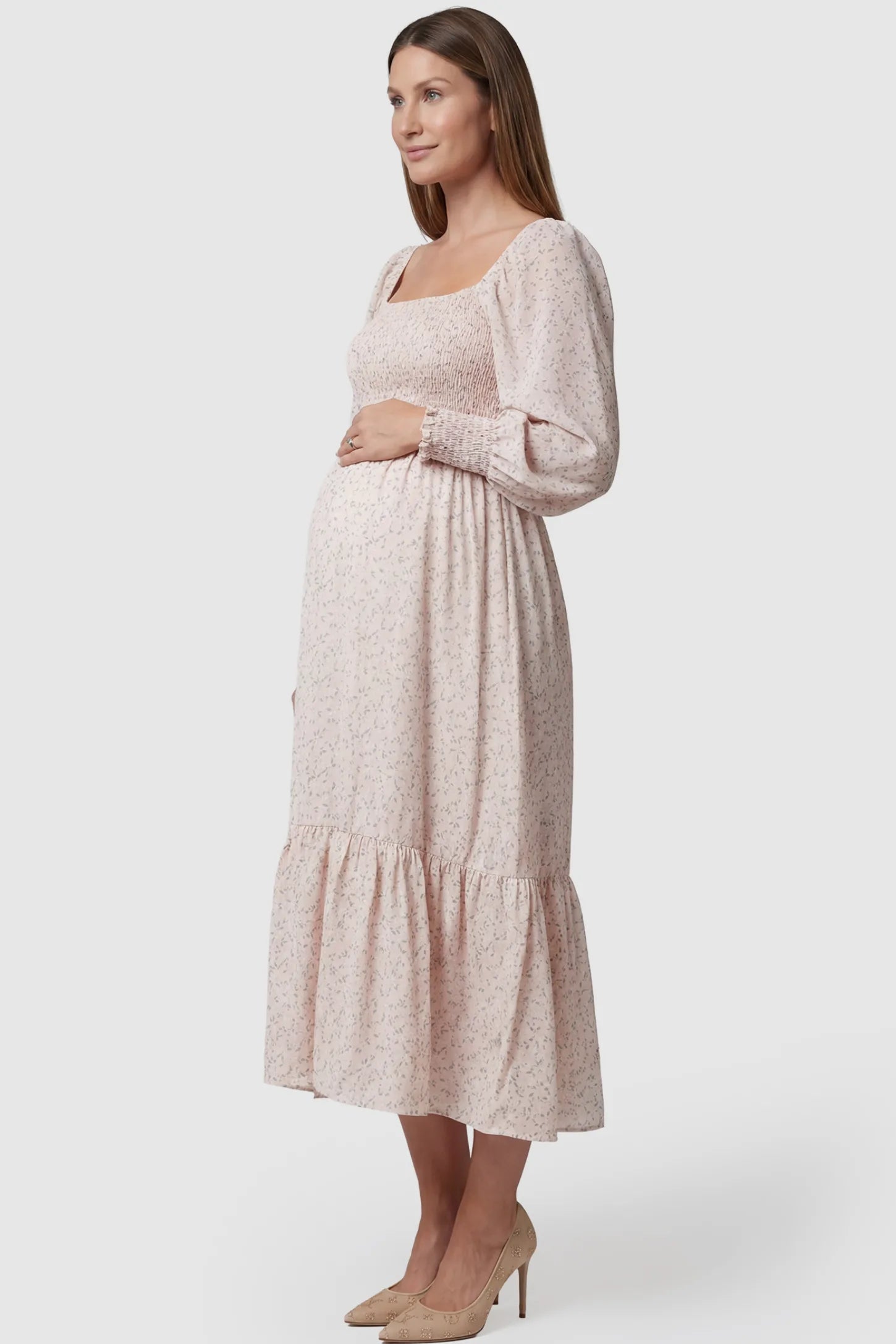 Floral Smocked Tiered Maternity Midi Dress Floral Smocked Tiered Maternity Midi Dress in soft pink floral print featuring square neckline, puff sleeves, and tiered midi skirt on pregnant model.