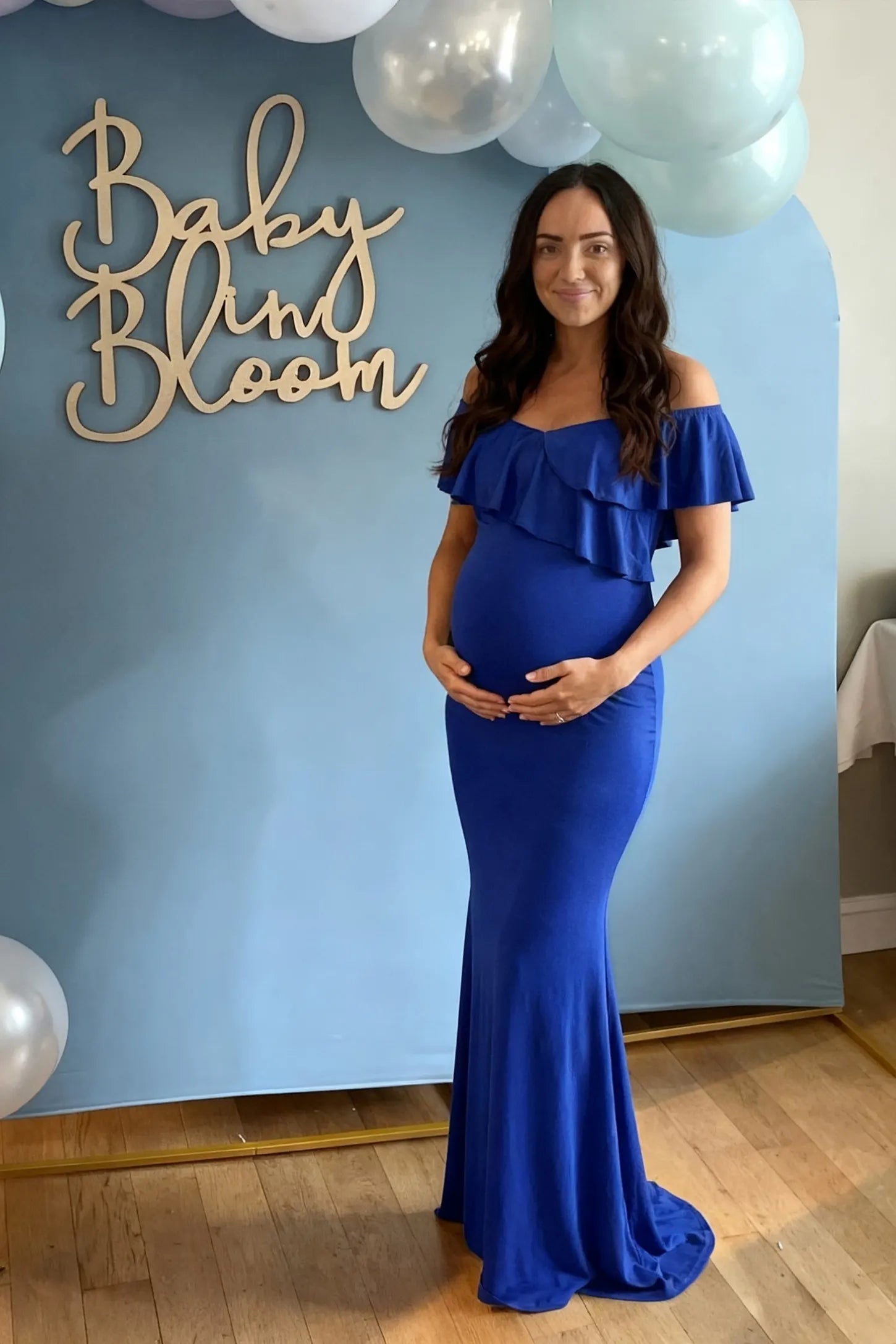 Ruffle Off-Shoulder Slim Fit Maxi Maternity Dress Ruffle off-shoulder slim fit maxi maternity dress in royal blue with flowing maxi length, on an editorial lifestyle model