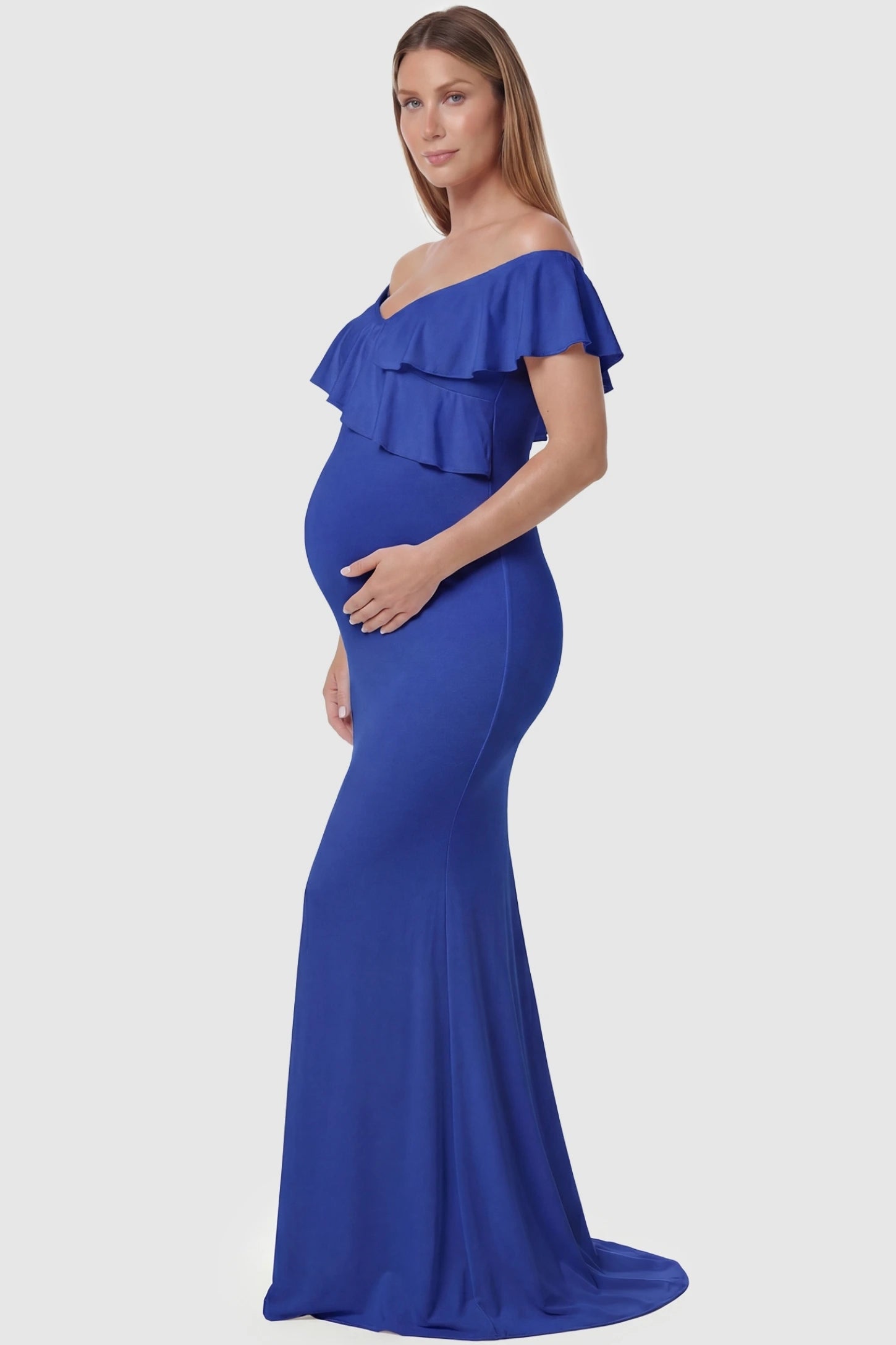 Ruffle Off-Shoulder Slim Fit Maxi Maternity Dress Ruffle off-shoulder slim fit maxi maternity dress in royal blue featuring off-shoulder and elegant ruffle detailing fabric in side view on a pregnant model