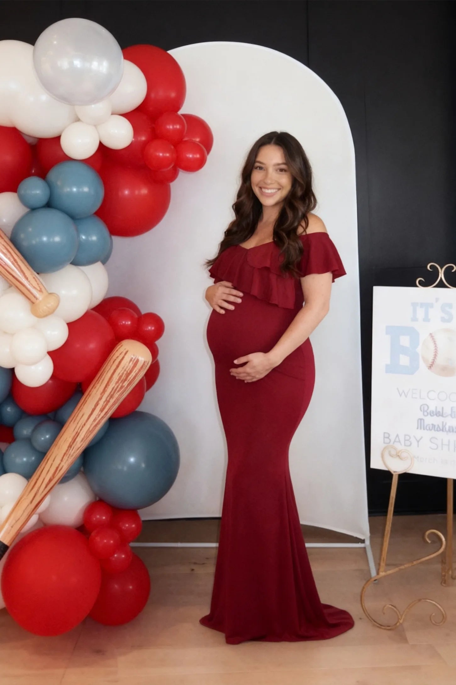 Ruffle Off-Shoulder Slim Fit Maxi Maternity Dress Ruffle off-shoulder slim fit maxi maternity dress in wine red with flowing maxi length, on an editorial lifestyle model