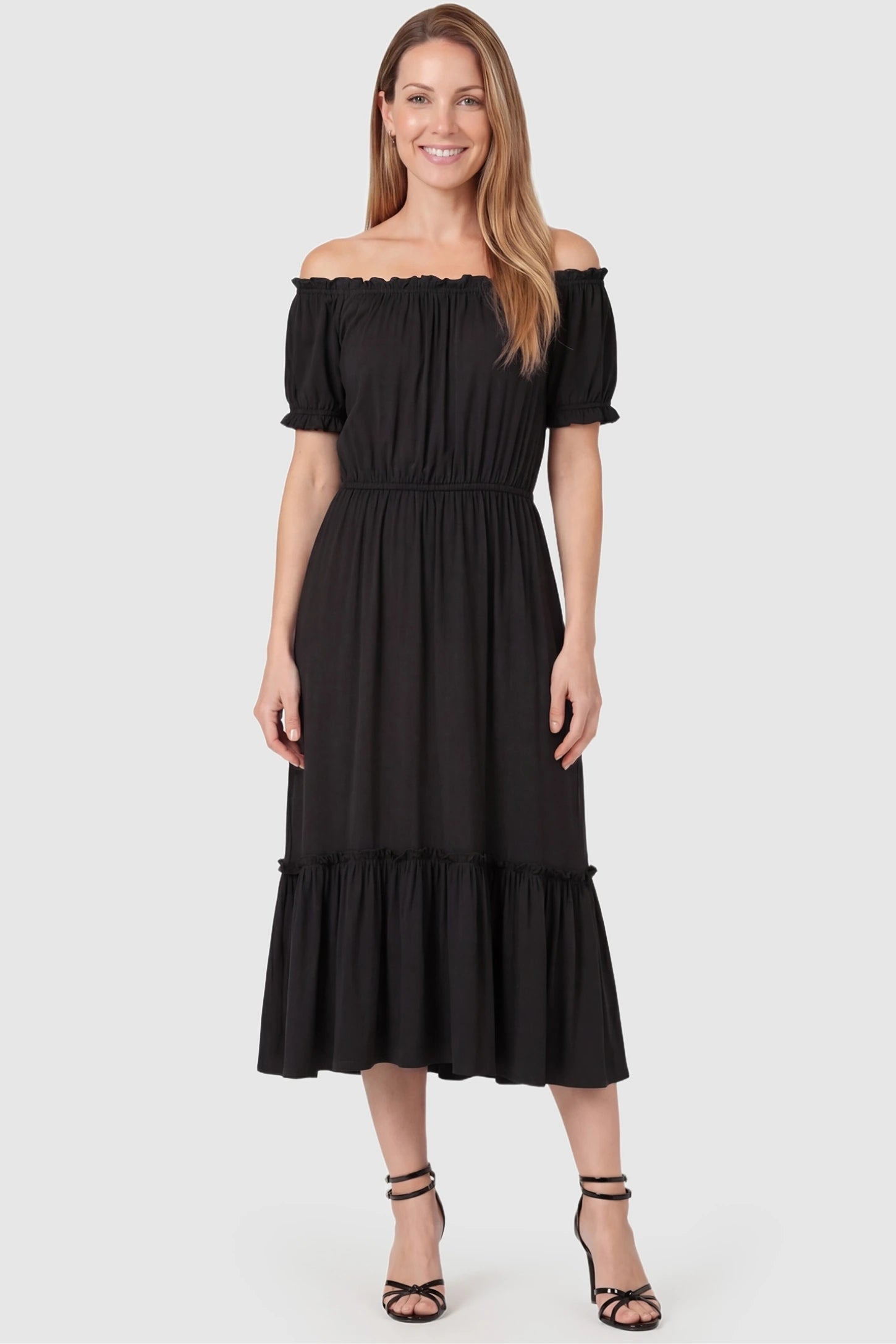 Ruffle Off-The-Shoulder Tiered Maternity Dress Ruffle Off-The-Shoulder Tiered Maternity Dress in Black featuring a flexible waist on a front-facing postpartum model.