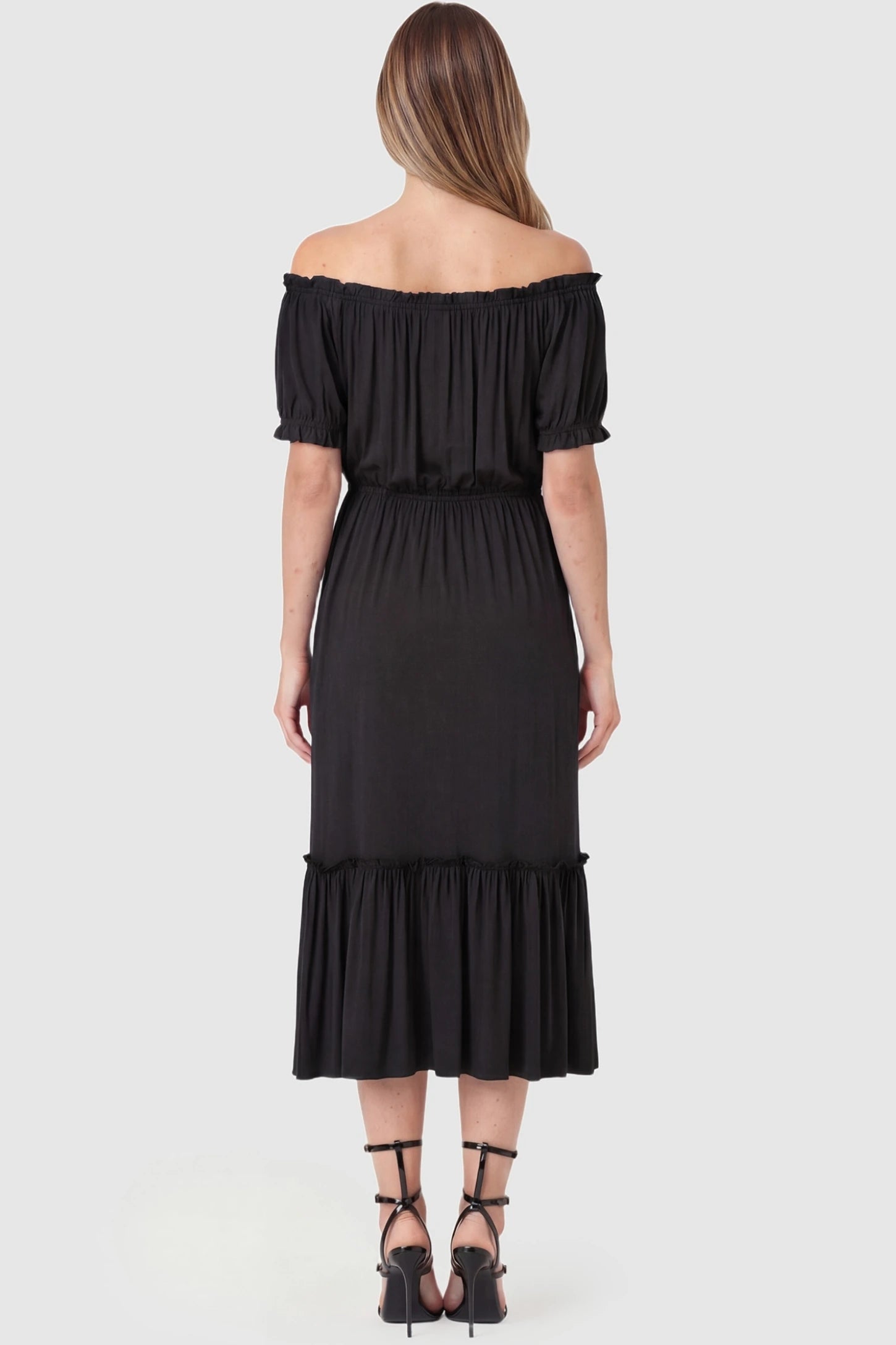 Ruffle Off-The-Shoulder Tiered Maternity Dress Ruffle Off-The-Shoulder Tiered Maternity Dress in Black featuring an elasticized open back on a pregnant model.