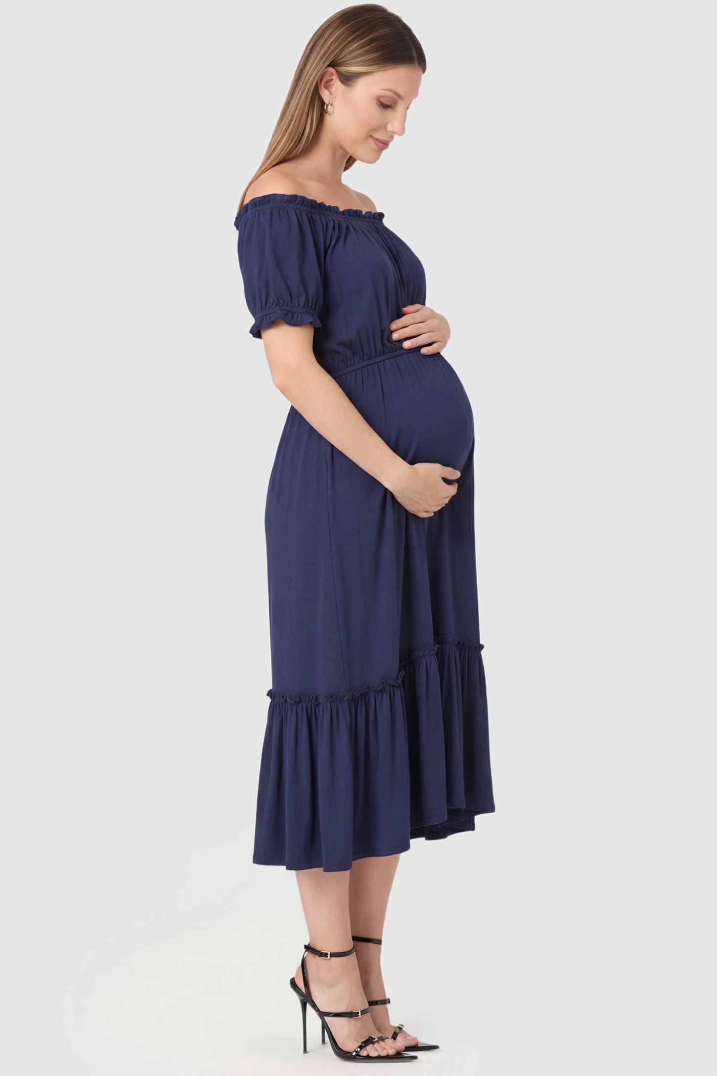 Ruffle Off-The-Shoulder Tiered Maternity Dress in Blue featuring a mid-length tiered skirt on a side-profile pregnant model.