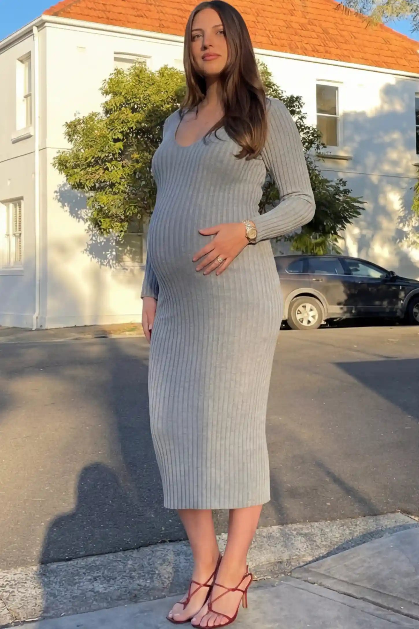 Ribbed V-Neck Long Sleeve Maternity Midi Dress Ribbed V-Neck Maternity Midi Dress in Gray featuring a fitted long sleeve on a pregnant model.