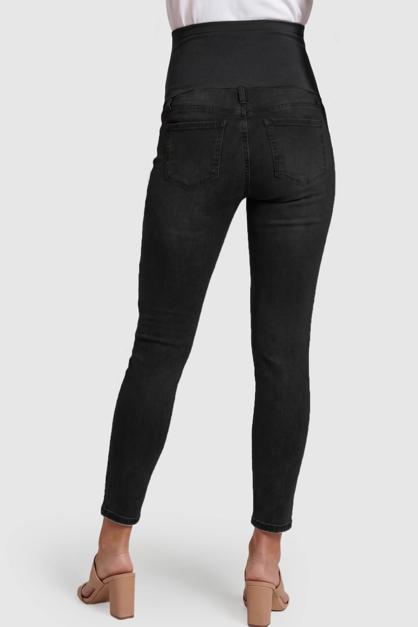 Full Panel Released Hem Maternity Skinny Jeans Full Panel Released Hem Maternity Skinny Jeans in Black featuring a released hem and over-the-belly panel on a pregnant model showing back.