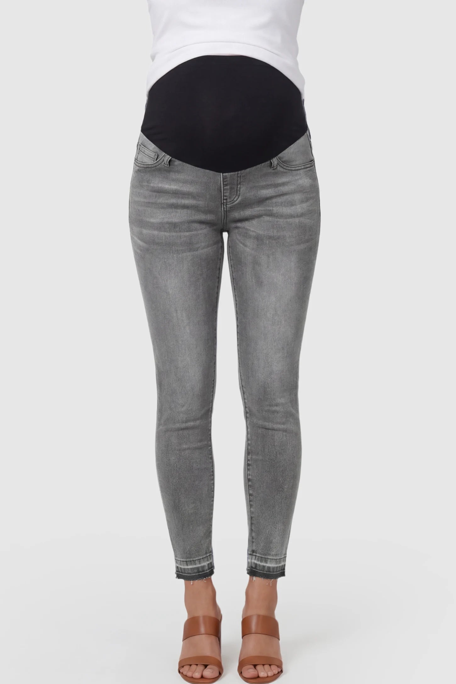 Full Panel Released Hem Maternity Skinny Jeans in Gray featuring a released hem and over-the-belly panel on a pregnant model showing front.