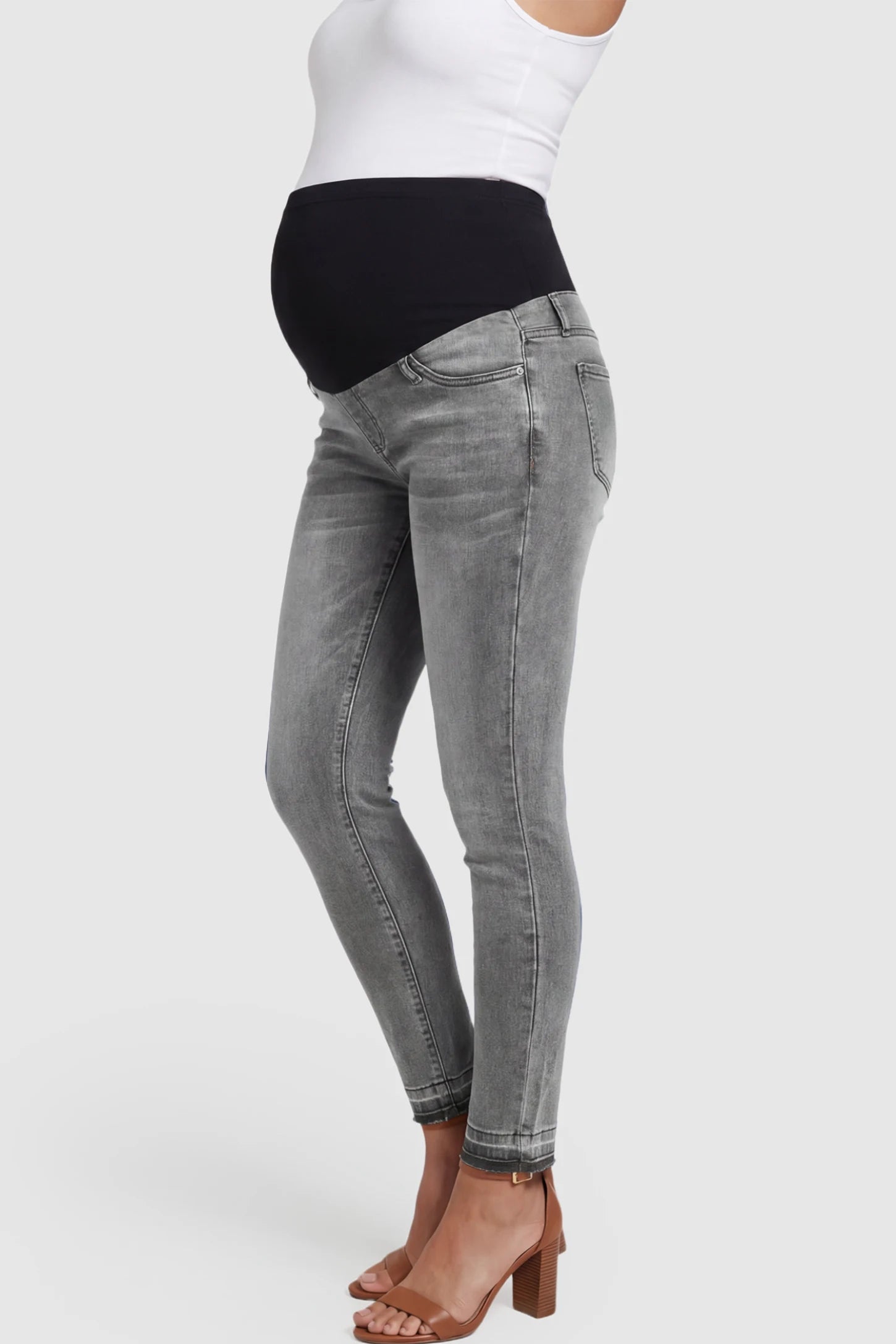 Full Panel Released Hem Maternity Skinny Jeans Full Panel Released Hem Maternity Skinny Jeans in Gray featuring a released hem and over-the-belly panel on a pregnant model showing side.