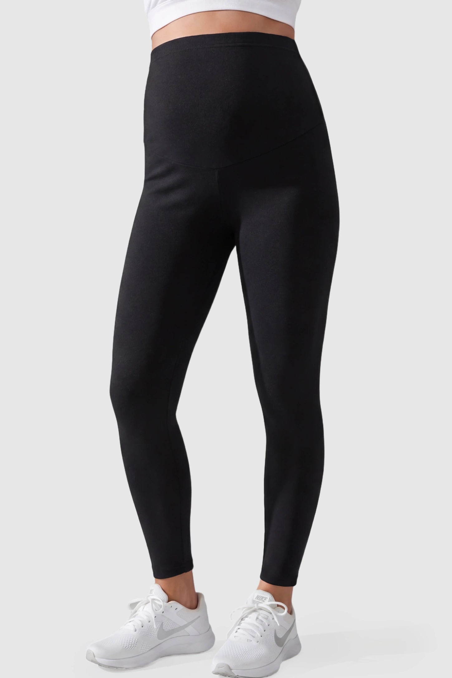 Full Panel Slim Fit Maternity Leggings Full Panel Slim Fit Maternity Leggings in Black featuring a seamless over-the-belly waistband on a pregnant model showing front.