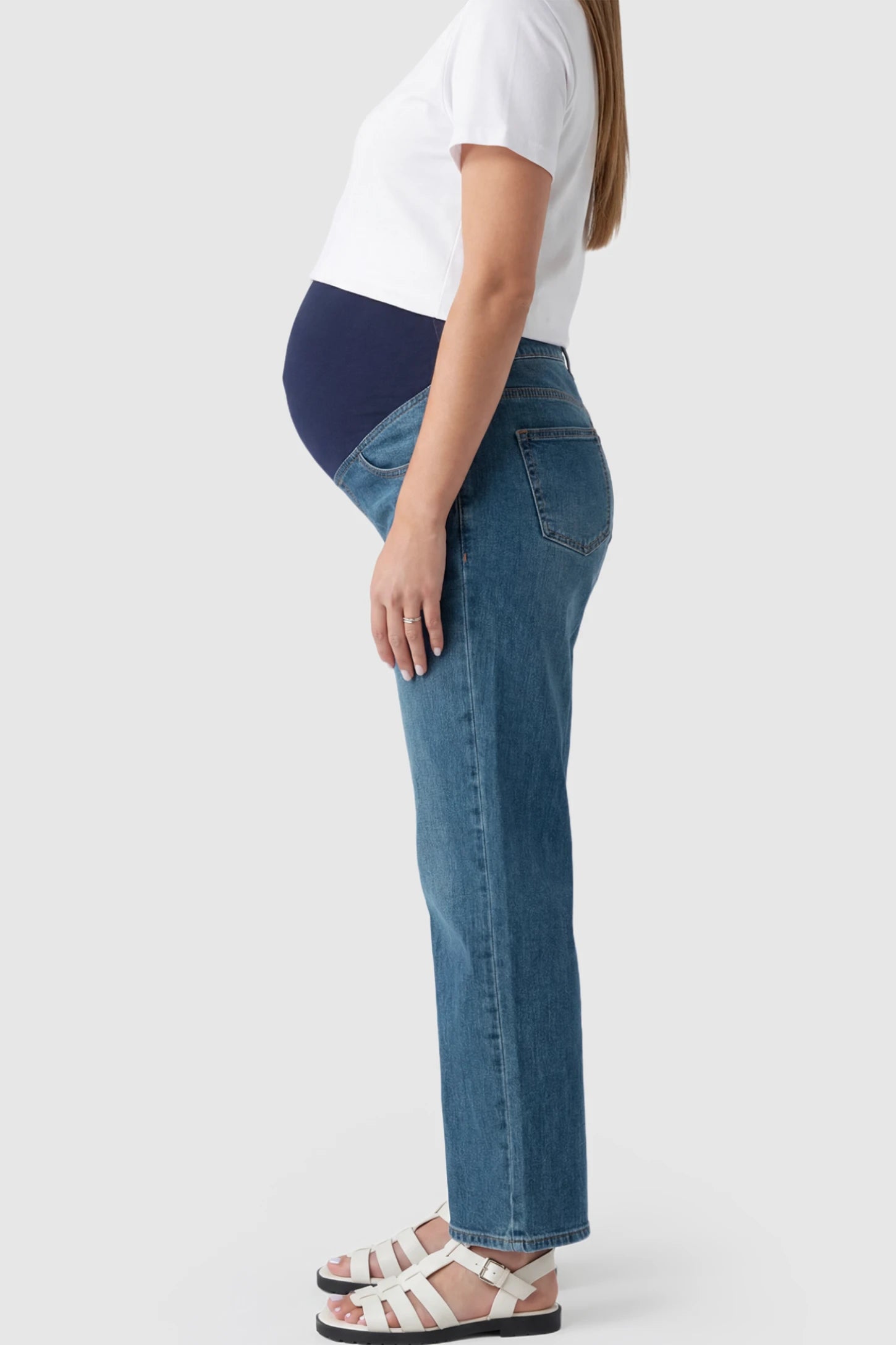 Full Panel Wide Leg Maternity Jeans Full Panel Wide Leg Maternity Jeans in Dark Blue featuring a seamless tummy-support band on a pregnant model showing side.