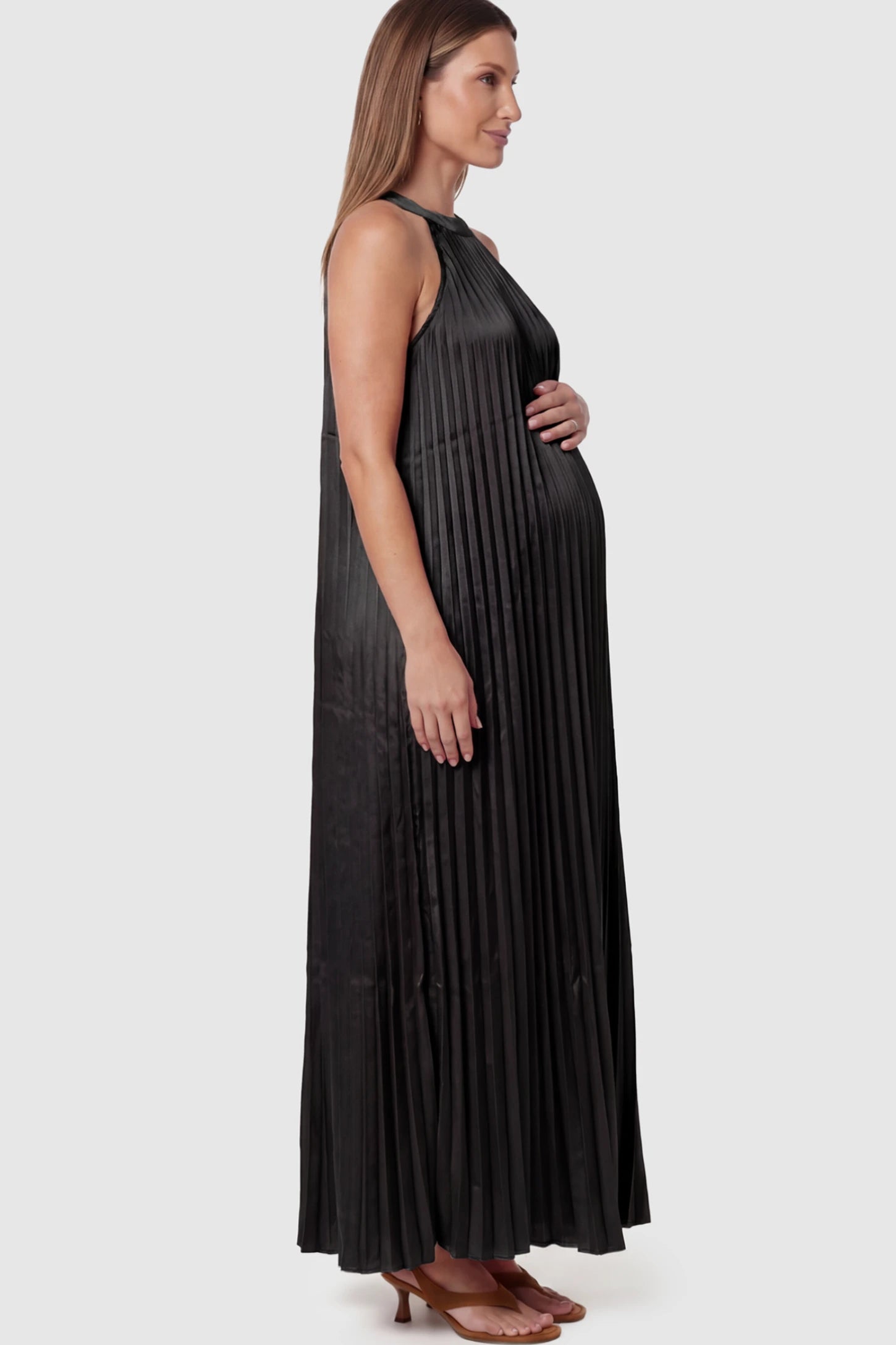 Pleated Faux Silk Halter Maternity Maxi Dress Pleated Faux Silk Halter Maternity Maxi Dress in Black featuring micro-pleat texture on a pregnant model facing left.