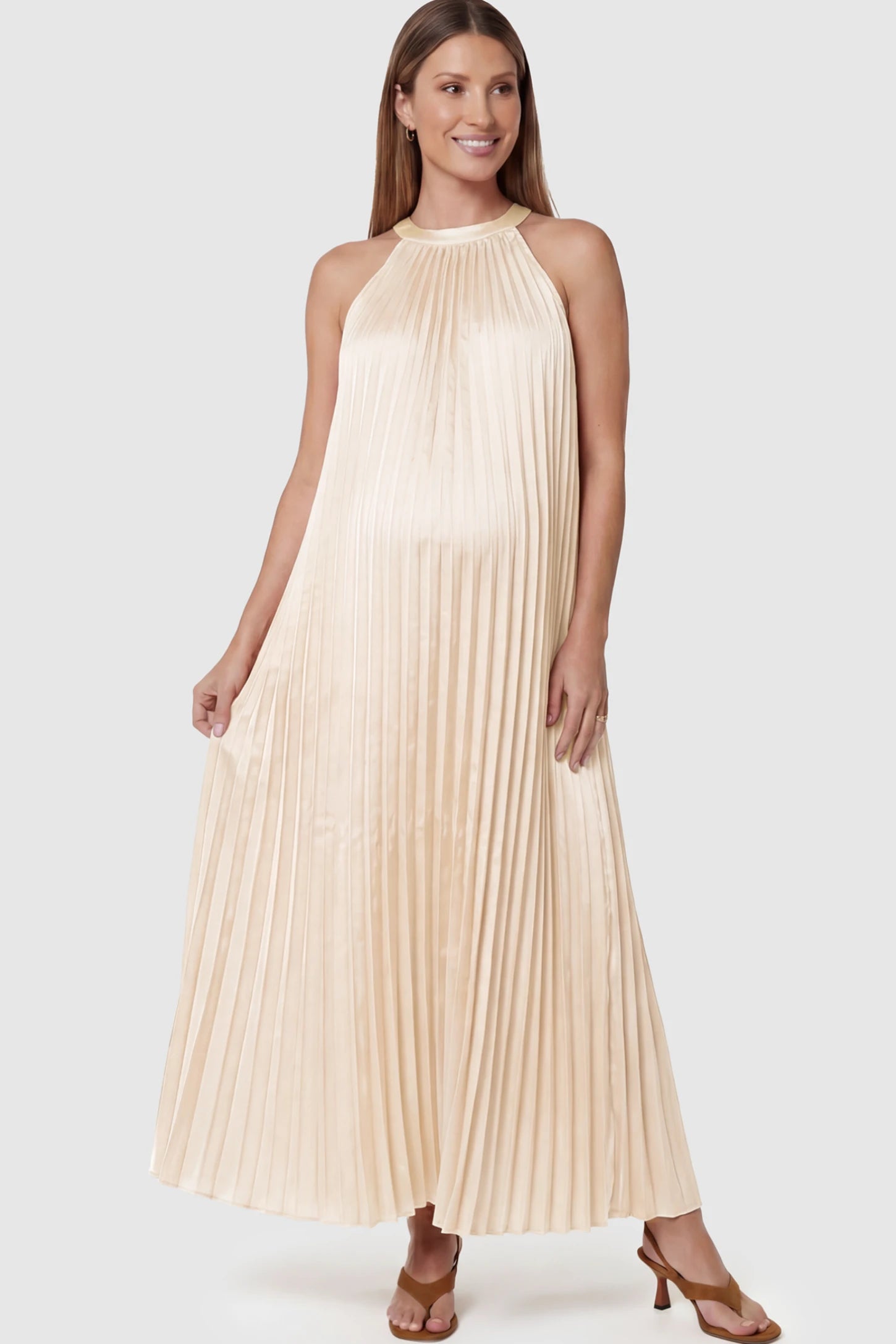 Pleated Faux Silk Halter Maternity Maxi Dress Pleated Faux Silk Halter Maternity Maxi Dress in Champagne featuring micro-pleat texture on a pregnant model facing front.