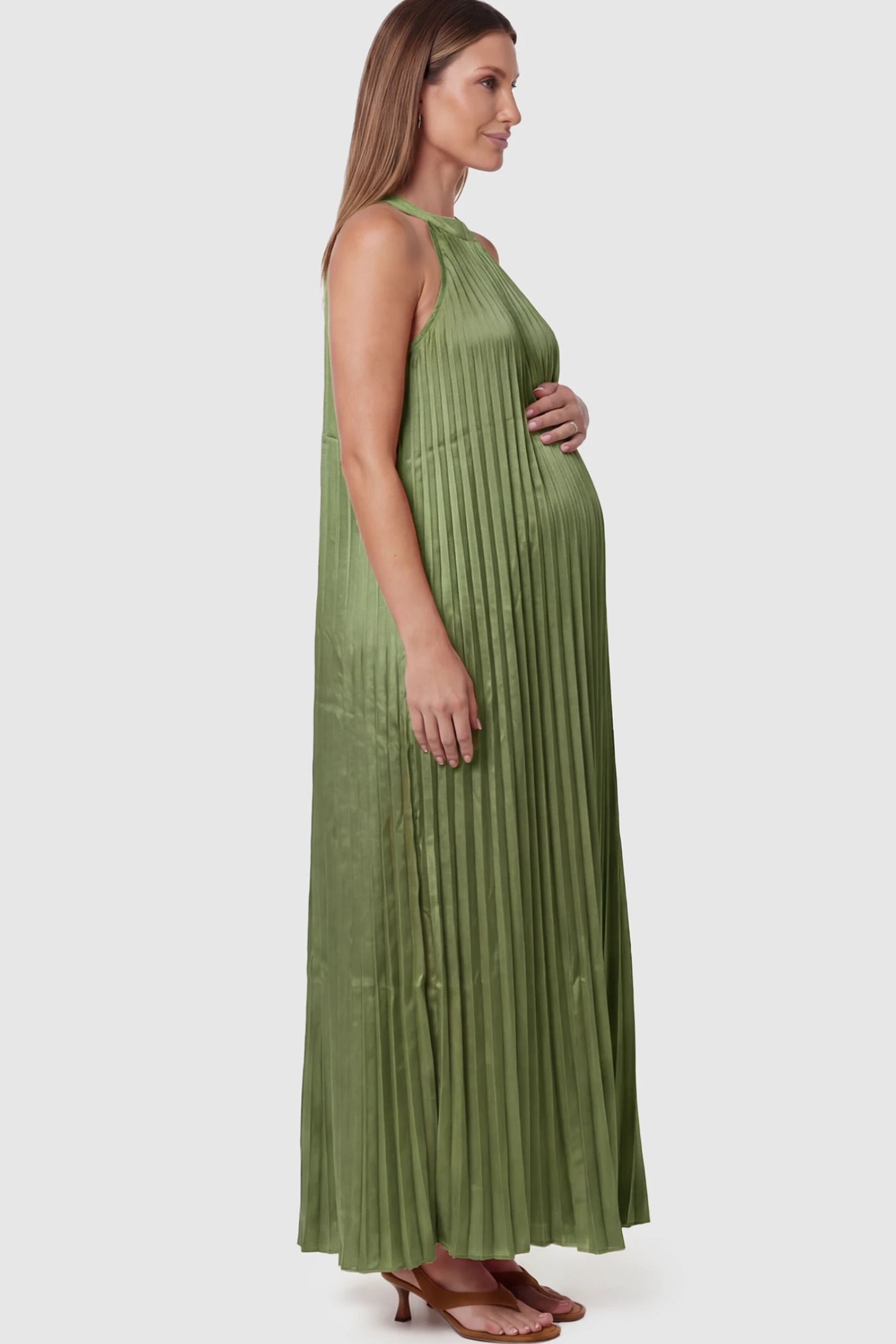 Pleated Faux Silk Halter Maternity Maxi Dress Pleated Faux Silk Halter Maternity Maxi Dress in Green featuring micro-pleat texture on a pregnant model facing left.