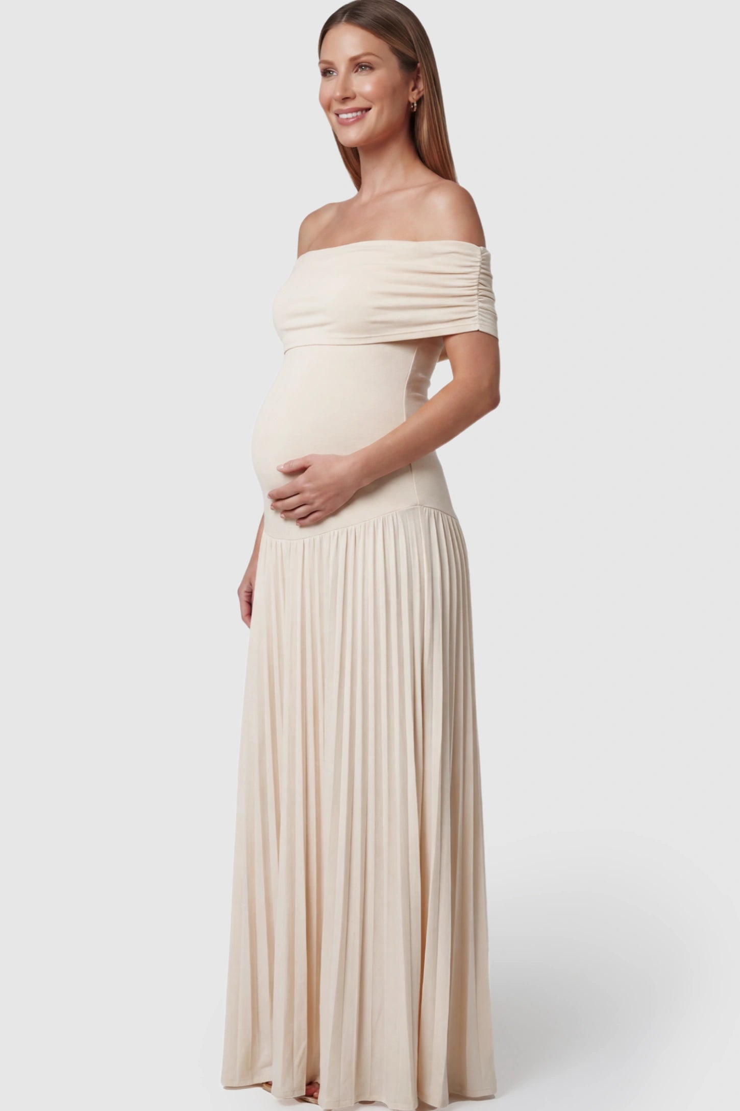 Pleated Off Shoulder Maternity Maxi Dress Pleated Off Shoulder Maternity Maxi Dress in Beige featuring a floor-length silhouette on a pregnant model.