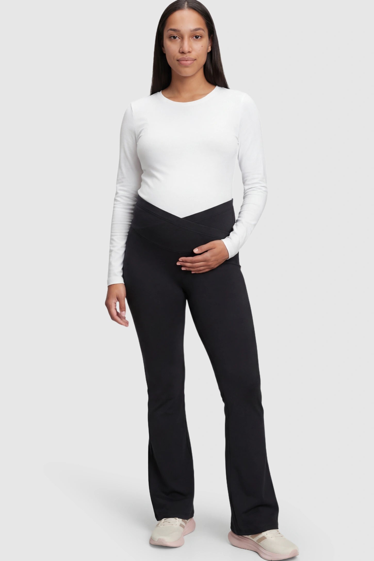 Crossover Waistline Flared Maternity Pants in Black featuring a V-shaped band on a pregnant model.