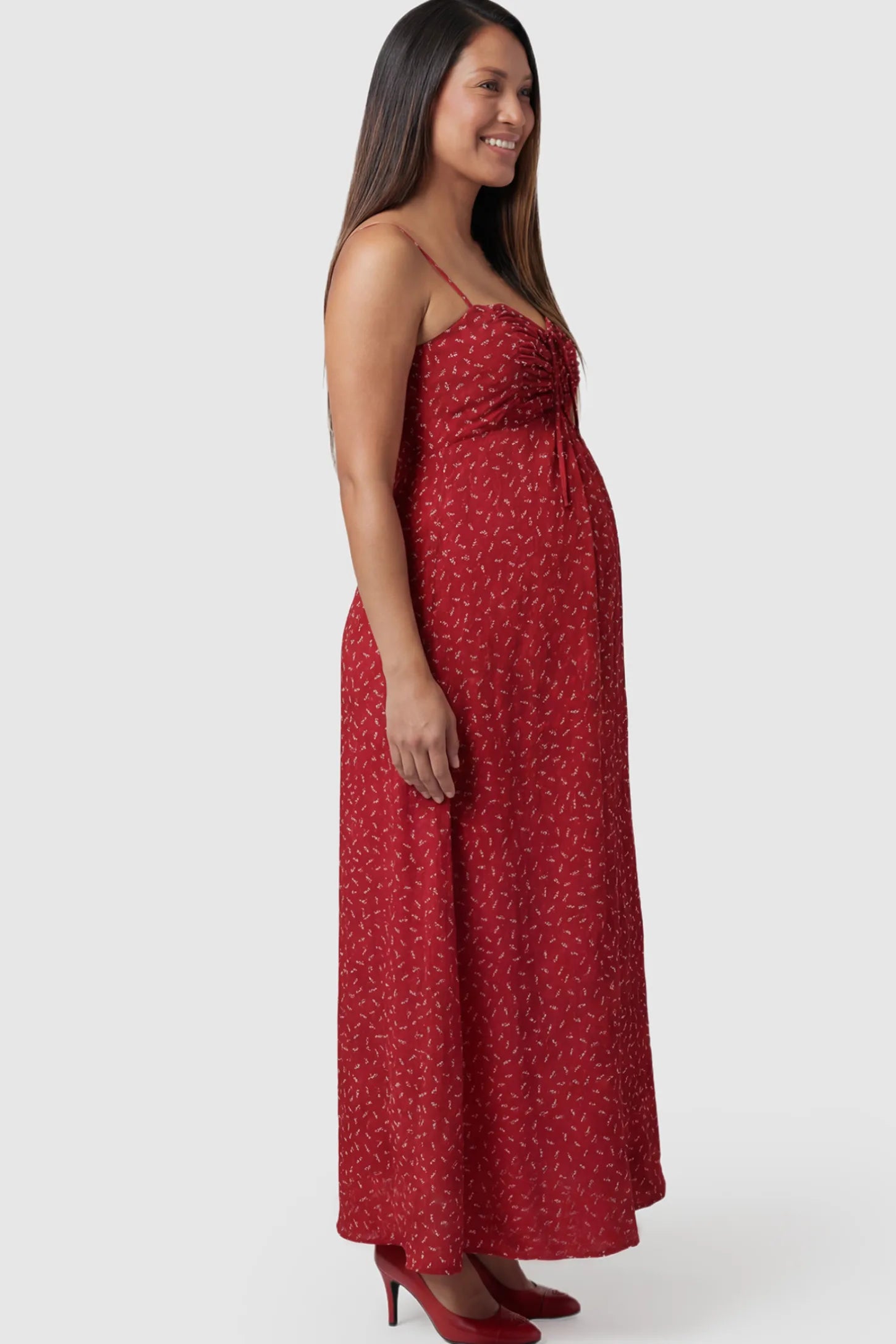 Floral Sweetheart Neck Pleated Midi Maternity Dress in Red Ditsy Floral featuring a delicate chiffon drape on a pregnant model.