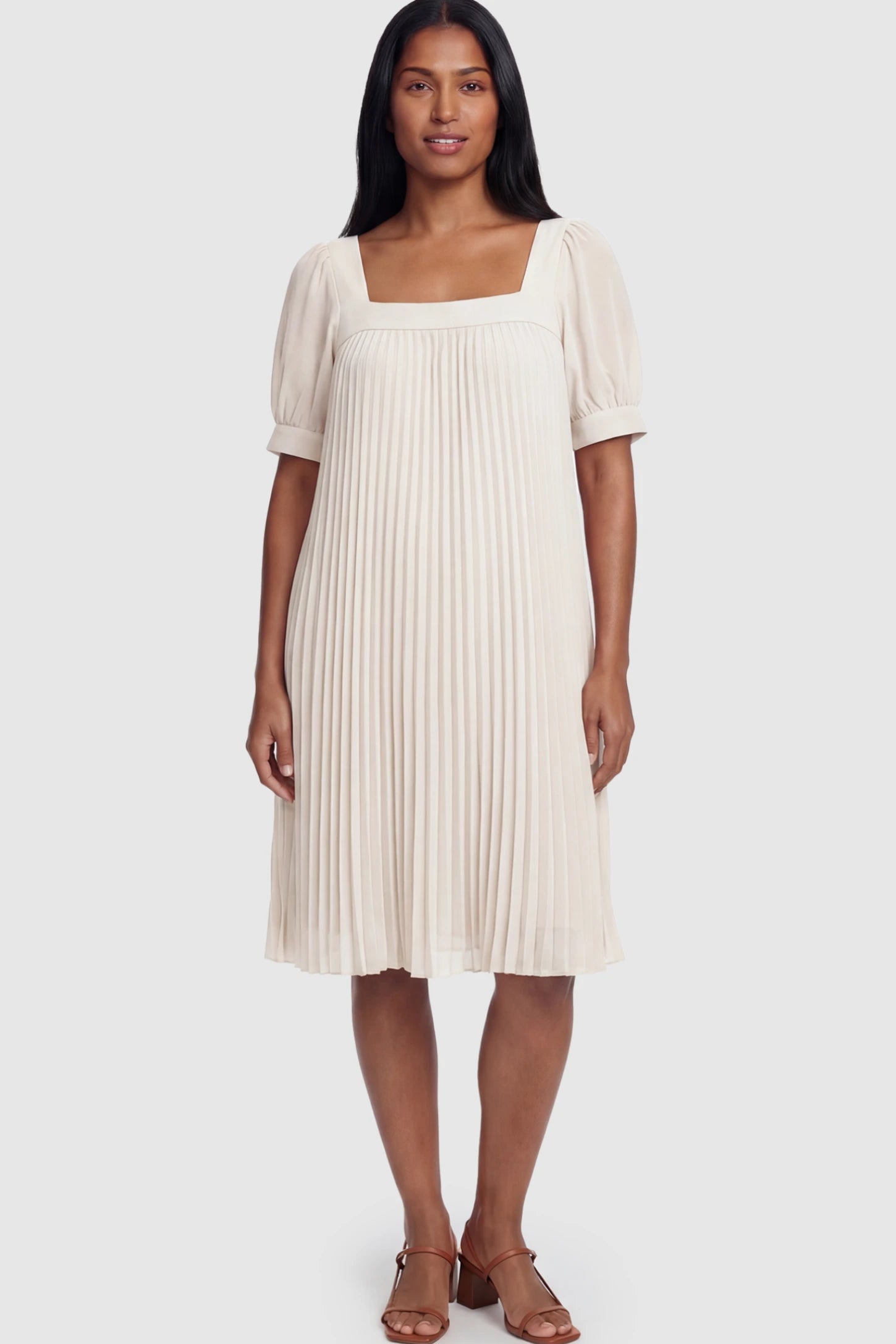 Pleated Front Square Neck Maternity Dress Pleated Front Square Neck Maternity Dress in Off White featuring accordion pleats and short sleeves on a postpartum model.