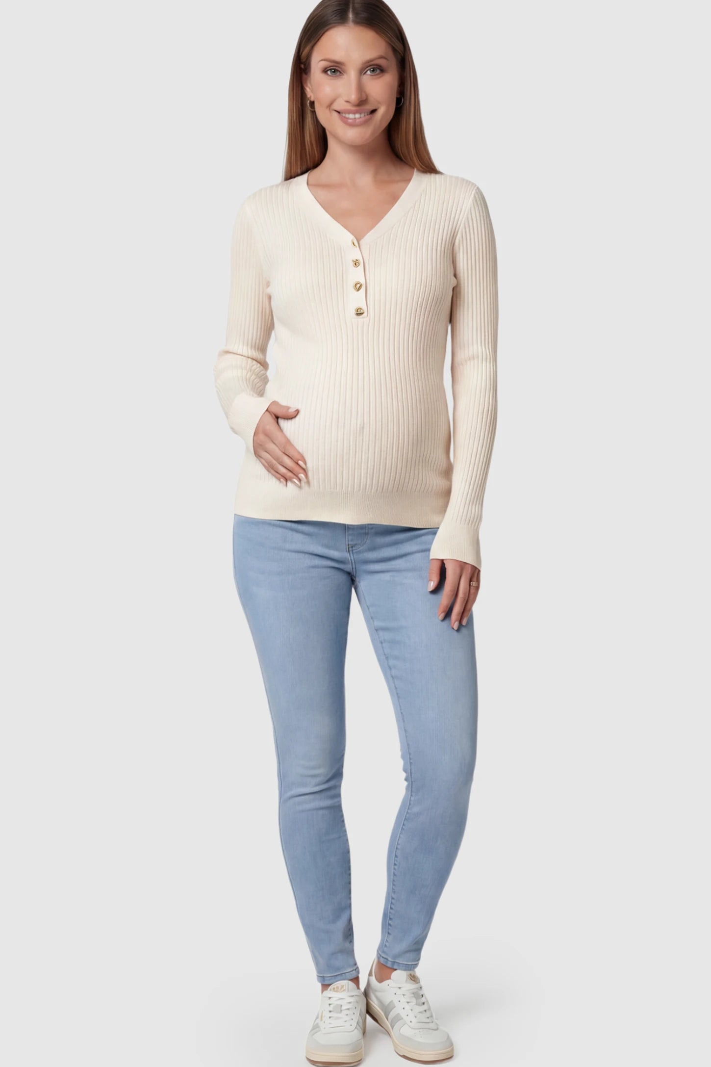 Ribbed Long Sleeve Maternity Henley Top Ribbed Maternity Henley Top in Apricot featuring a functional button placket and vertical rib knit on a pregnant model.