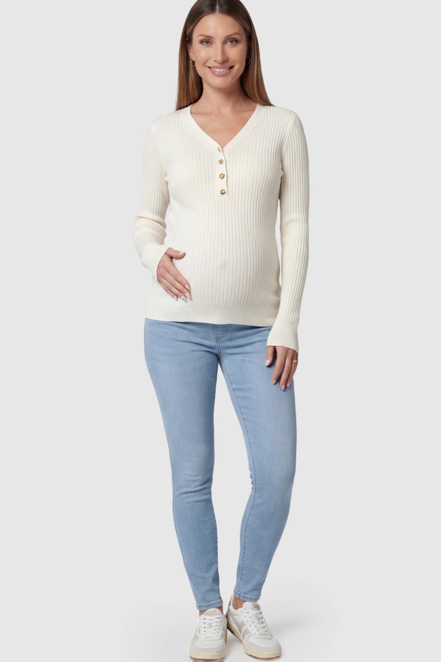 Ribbed Long Sleeve Maternity Henley Top Ribbed Maternity Henley Top in Off White featuring a functional button placket and vertical rib knit on a pregnant model.