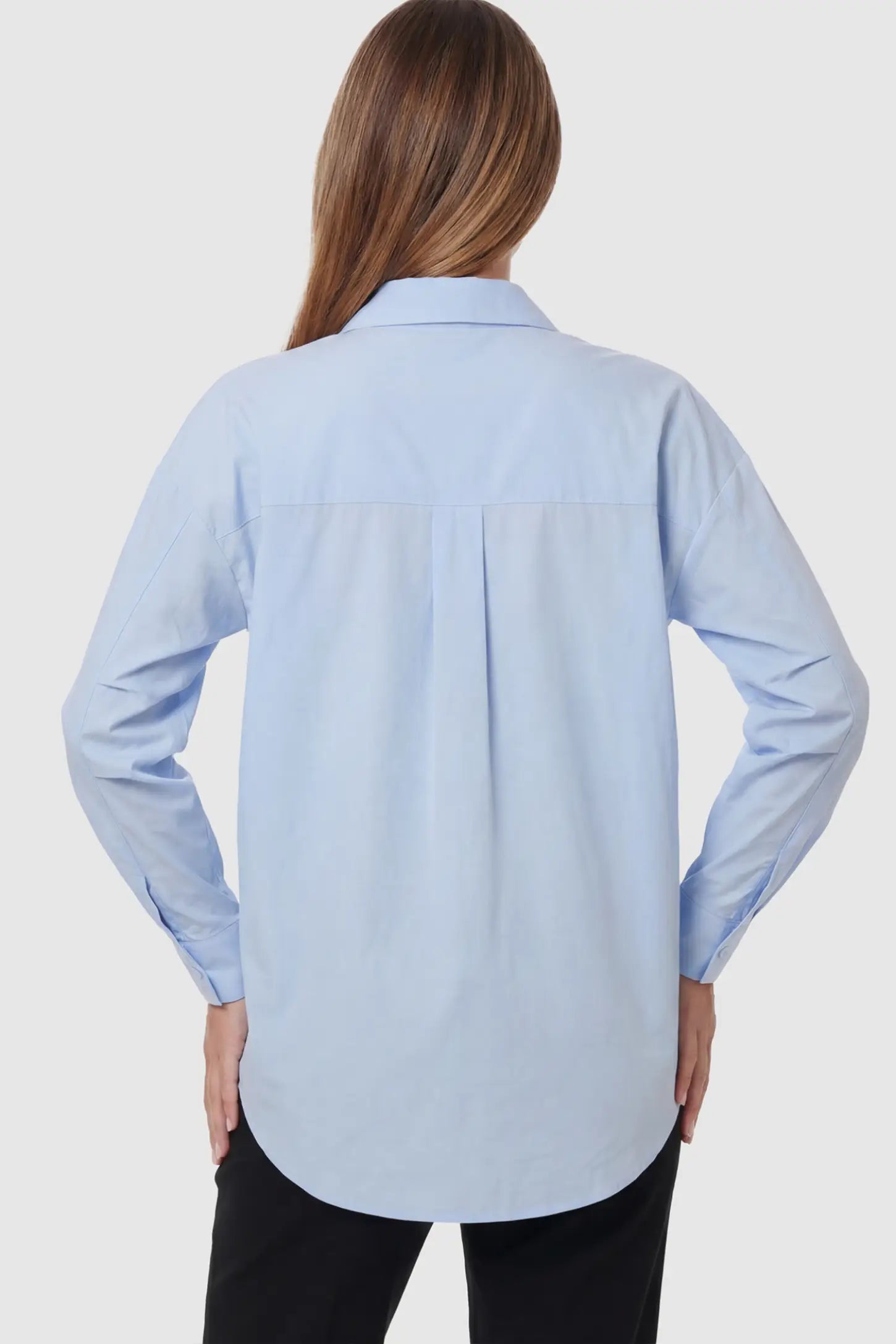 Button Down Collared Maternity Shirt Button Down Collared Maternity Shirt in Light Blue featuring long sleeves and a crisp cotton finish on a pregnant model.