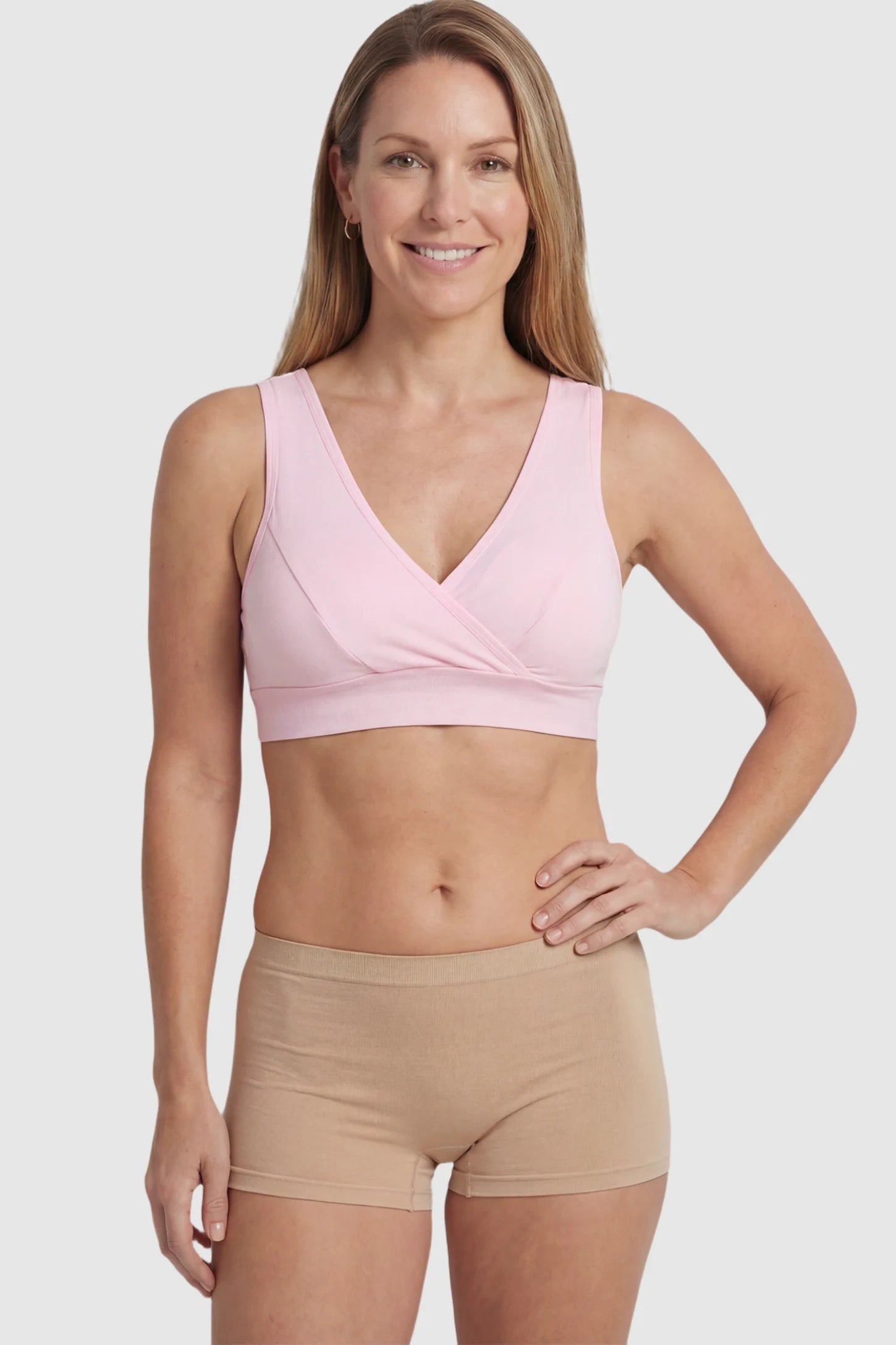 Soft Cotton Crossover Wireless Maternity Nursing Bra Soft Cotton Crossover Wireless Pull-On Maternity Nursing Bra in Pink featuring a wrap-front design on a postpartum model.