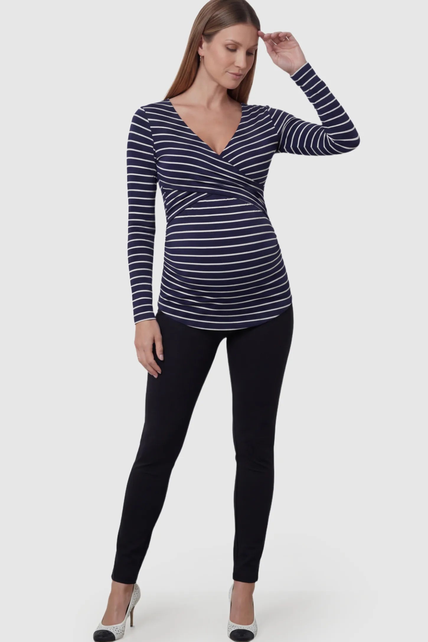 Striped Wrap Front Maternity & Nursing Top Striped Wrap Front Nursing Top in navy blue with crossover neckline on a pregnant model.
