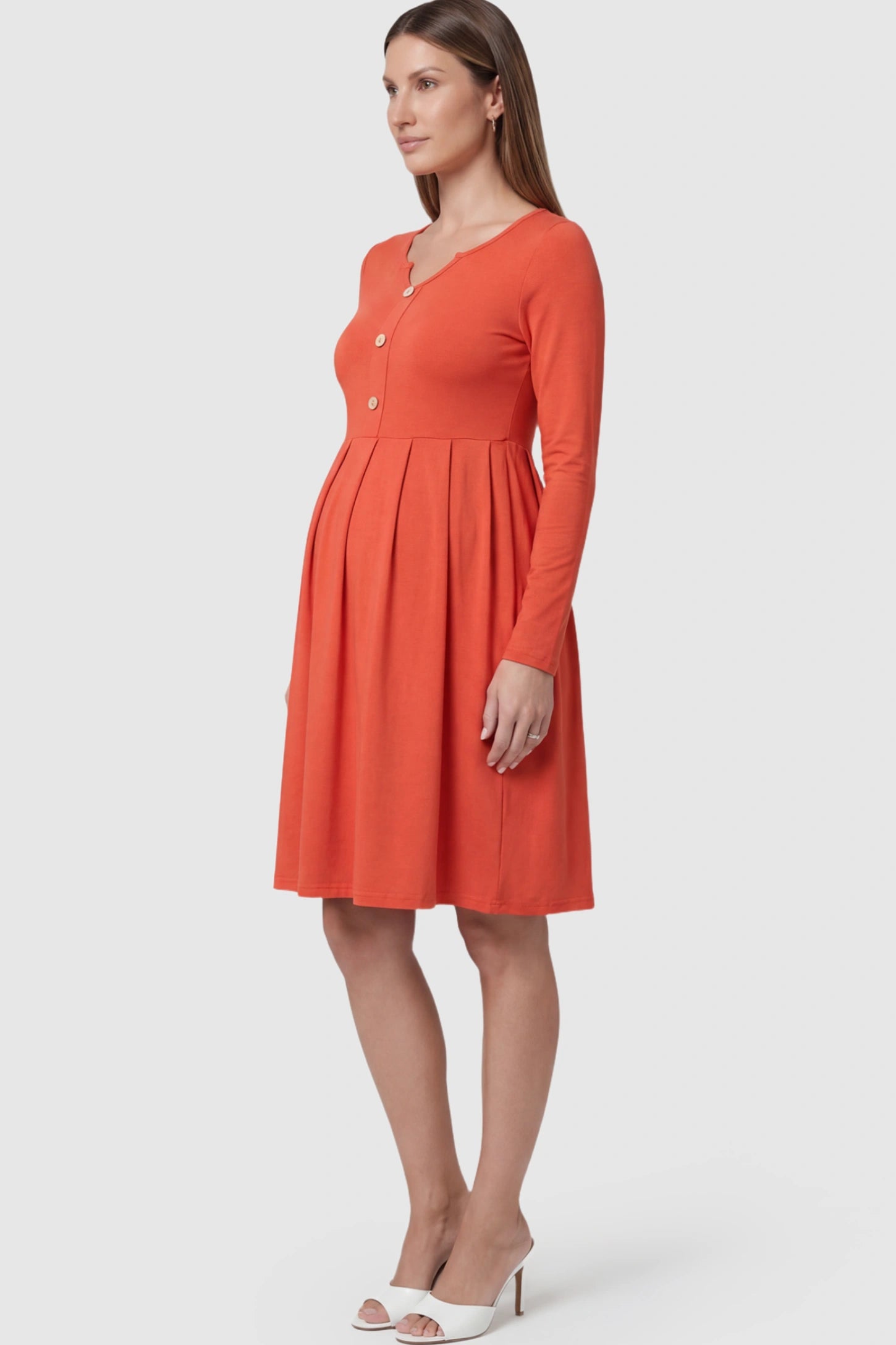 Button Accent Pleated Empire Waist Maternity Short Dress in Orange featuring a high-set waist on a pregnant model.