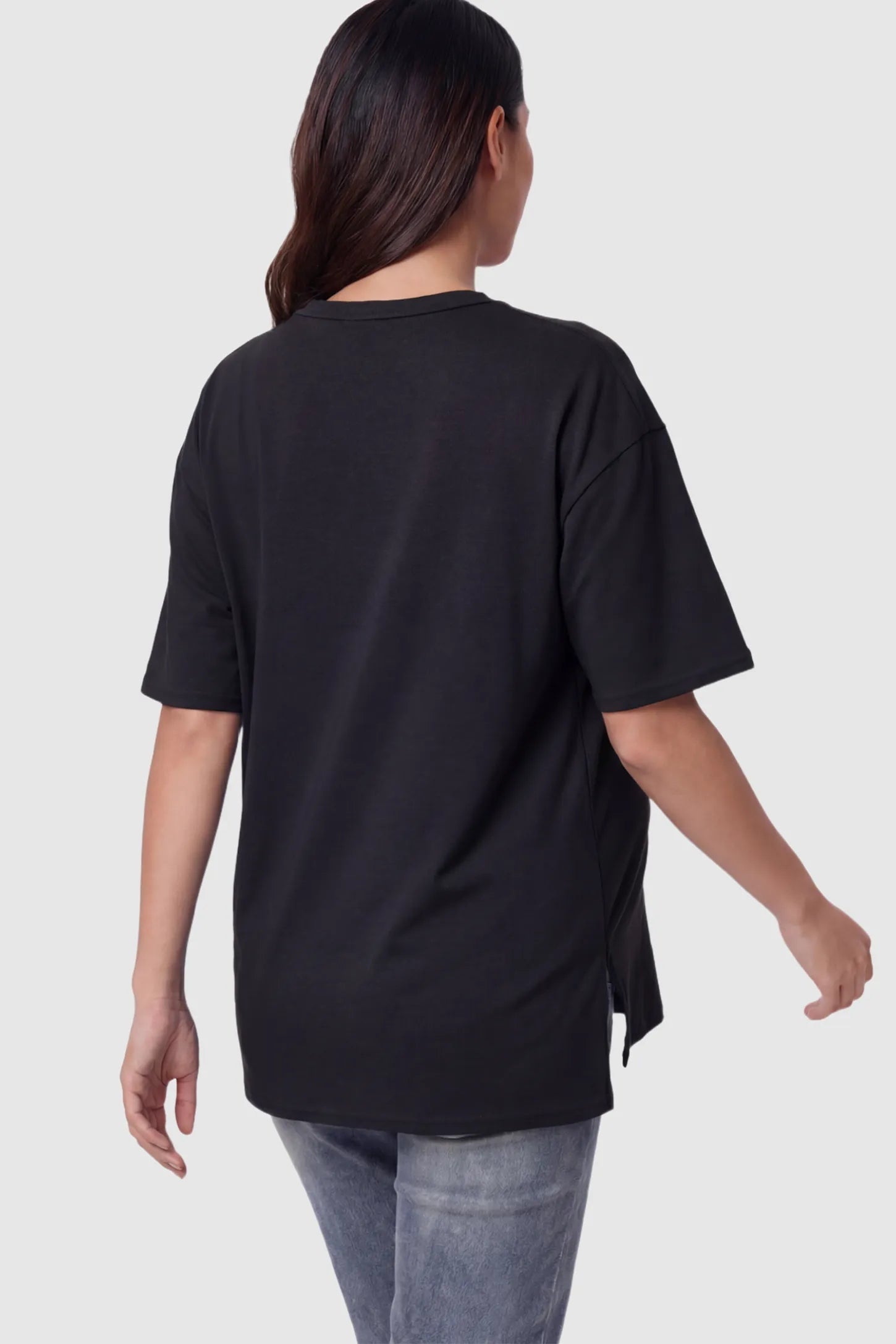 Crew Neck Short Sleeve Maternity T-Shirt Maternity Side-Slit Crew Neck Short Sleeve in Black featuring an oversized wrinkle-resistant fit on a pregnant model.