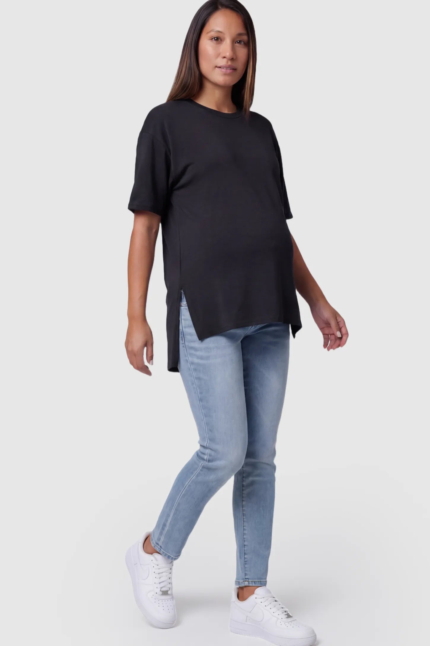 Crew Neck Short Sleeve Maternity T-Shirt Maternity Side-Slit Crew Neck Short Sleeve in Black featuring an oversized wrinkle-resistant fit on a pregnant model.
