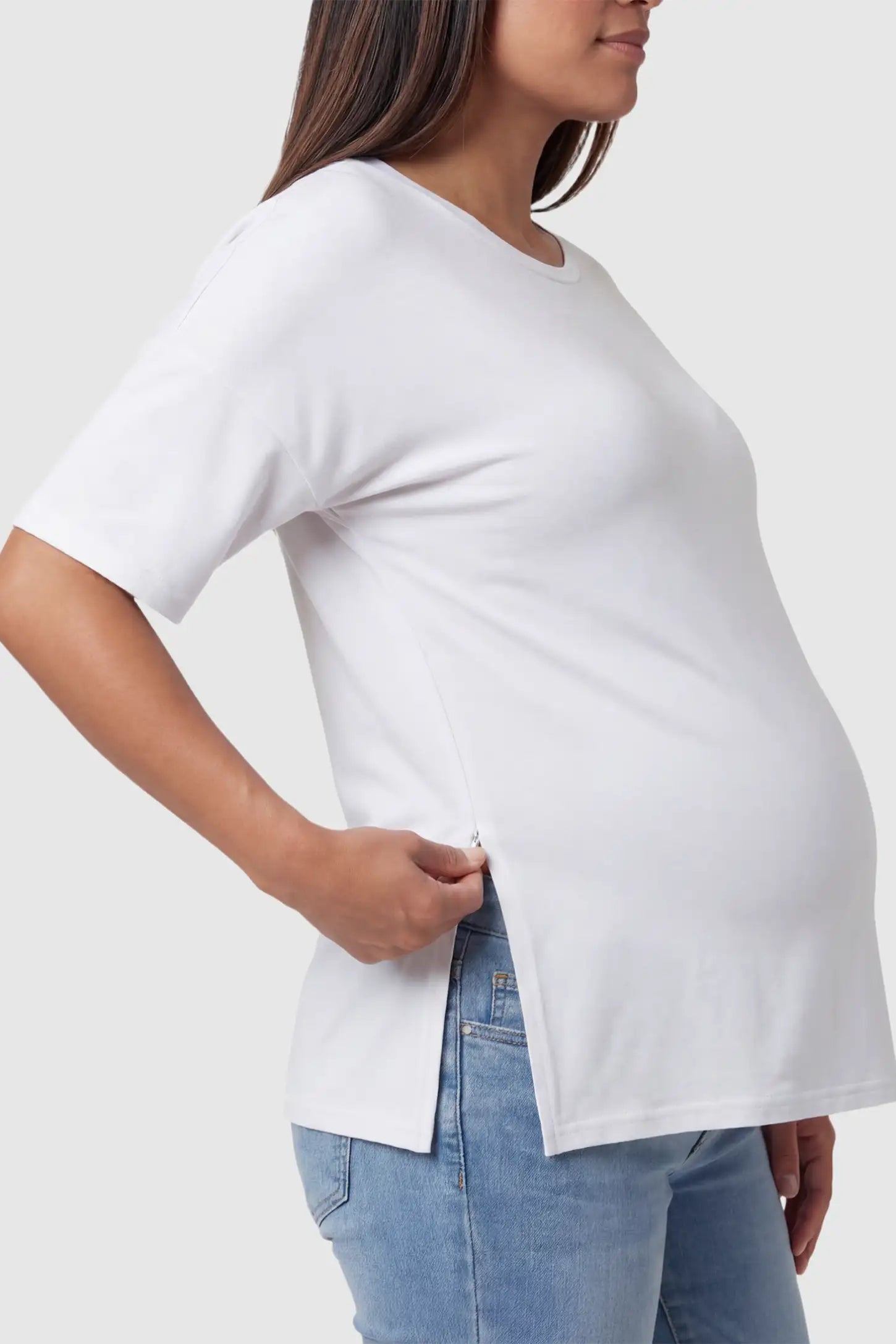 Crew Neck Short Sleeve Maternity T-Shirt Maternity Side-Slit Crew Neck Short Sleeve in White featuring an oversized wrinkle-resistant fit on a pregnant model.