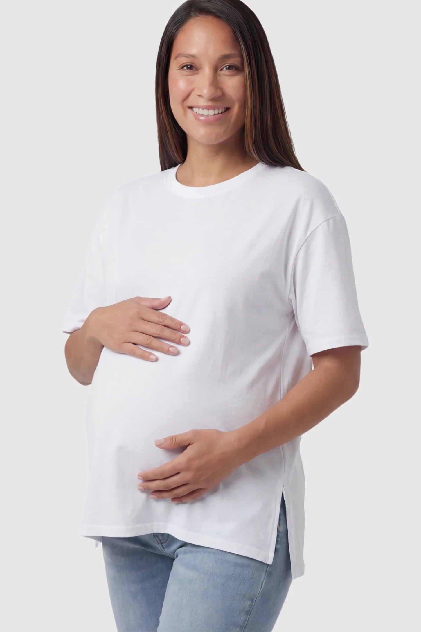 Crew Neck Short Sleeve Maternity T-Shirt Maternity Side-Slit Crew Neck Short Sleeve in White featuring an oversized wrinkle-resistant fit on a pregnant model.