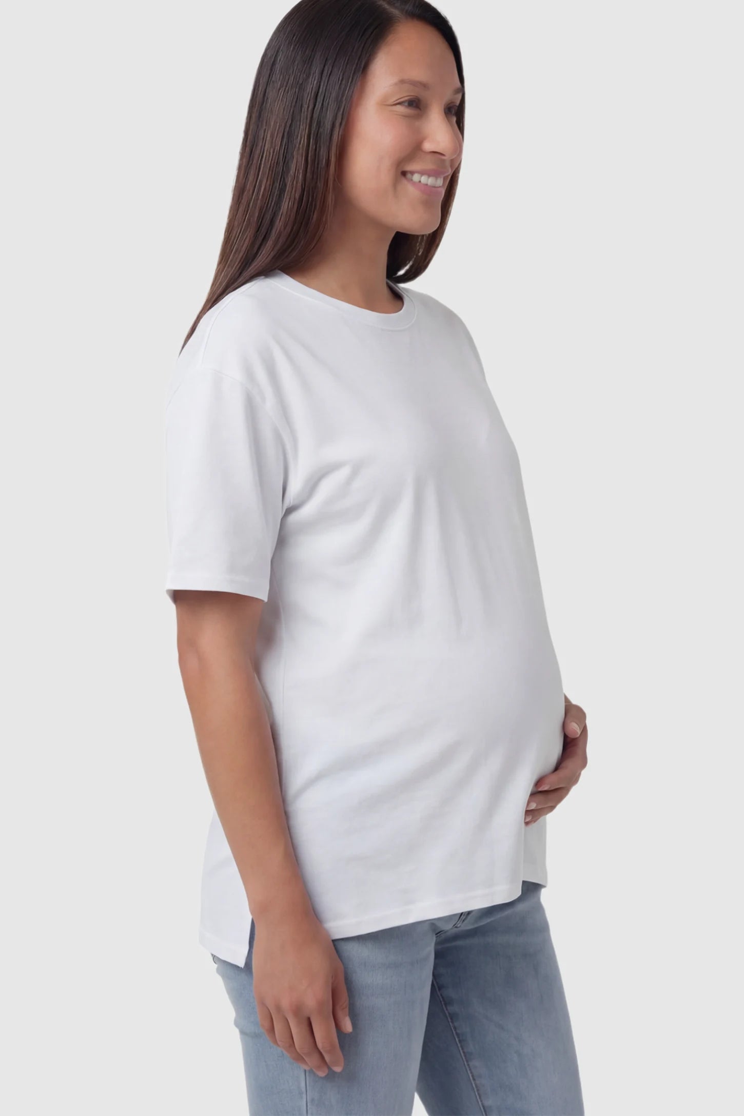 Crew Neck Short Sleeve Maternity T-Shirt Maternity Side-Slit Crew Neck Short Sleeve in White featuring an oversized wrinkle-resistant fit on a pregnant model.