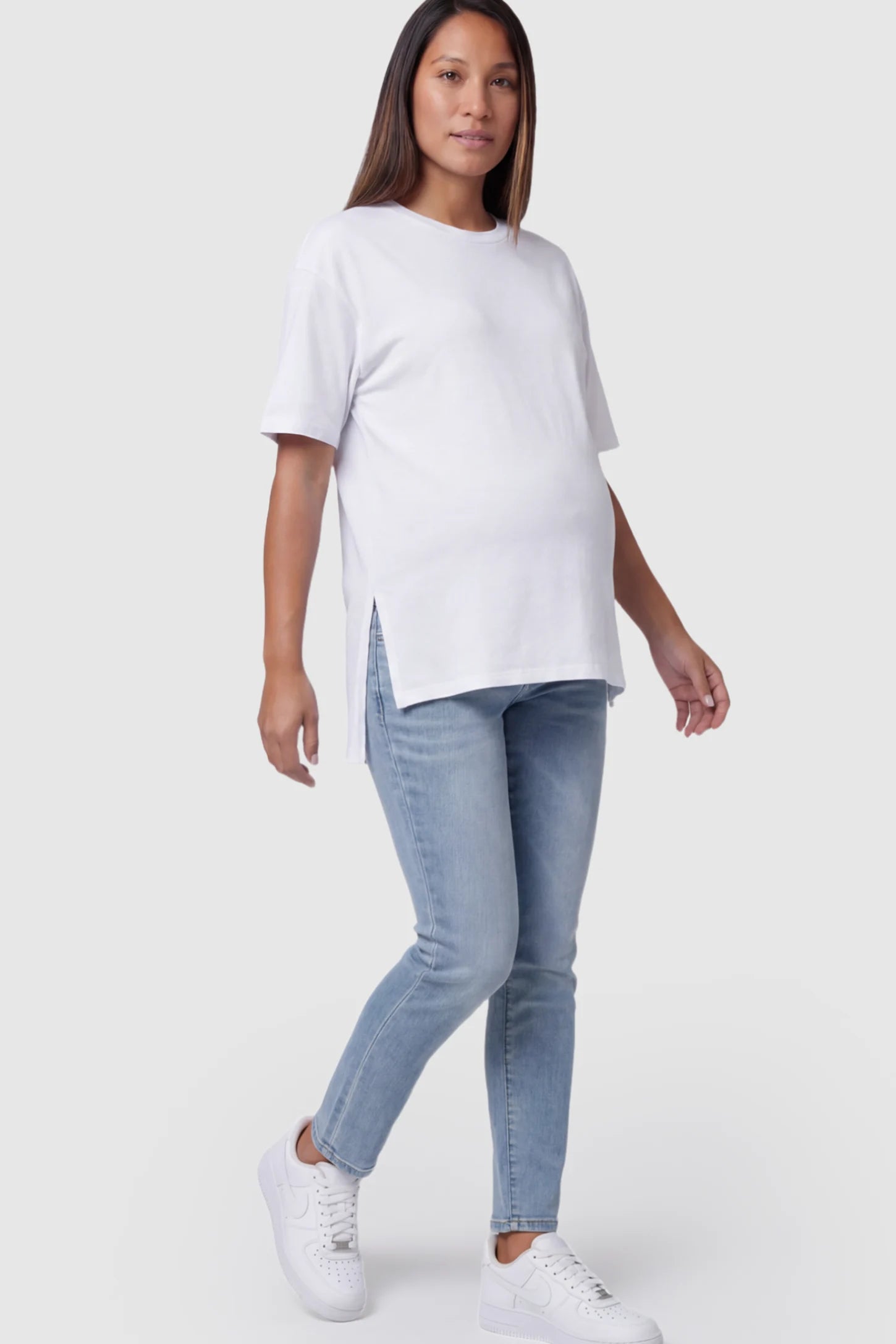 Crew Neck Short Sleeve Maternity T-Shirt Maternity Side-Slit Crew Neck Short Sleeve in White featuring an oversized wrinkle-resistant fit on a pregnant model.