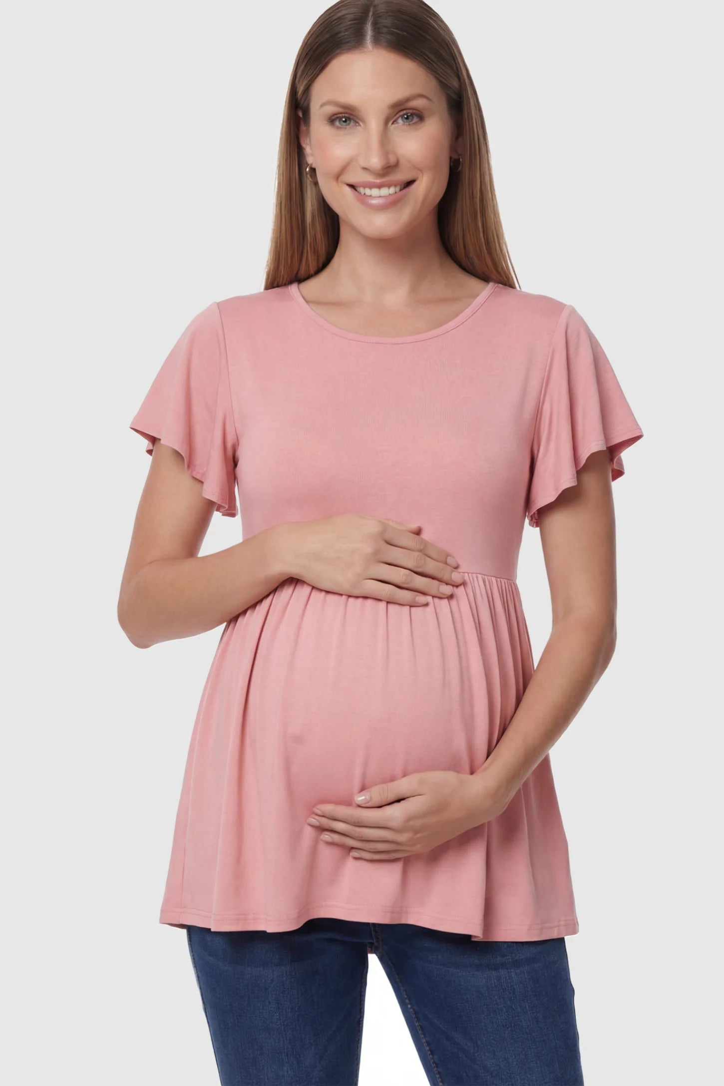 Solid Ruffled-Sleeve Flowy Maternity Top Solid Ruffled-Sleeve Flowy Maternity Top in Pink featuring a pleated empire waist on a pregnant model in front view.