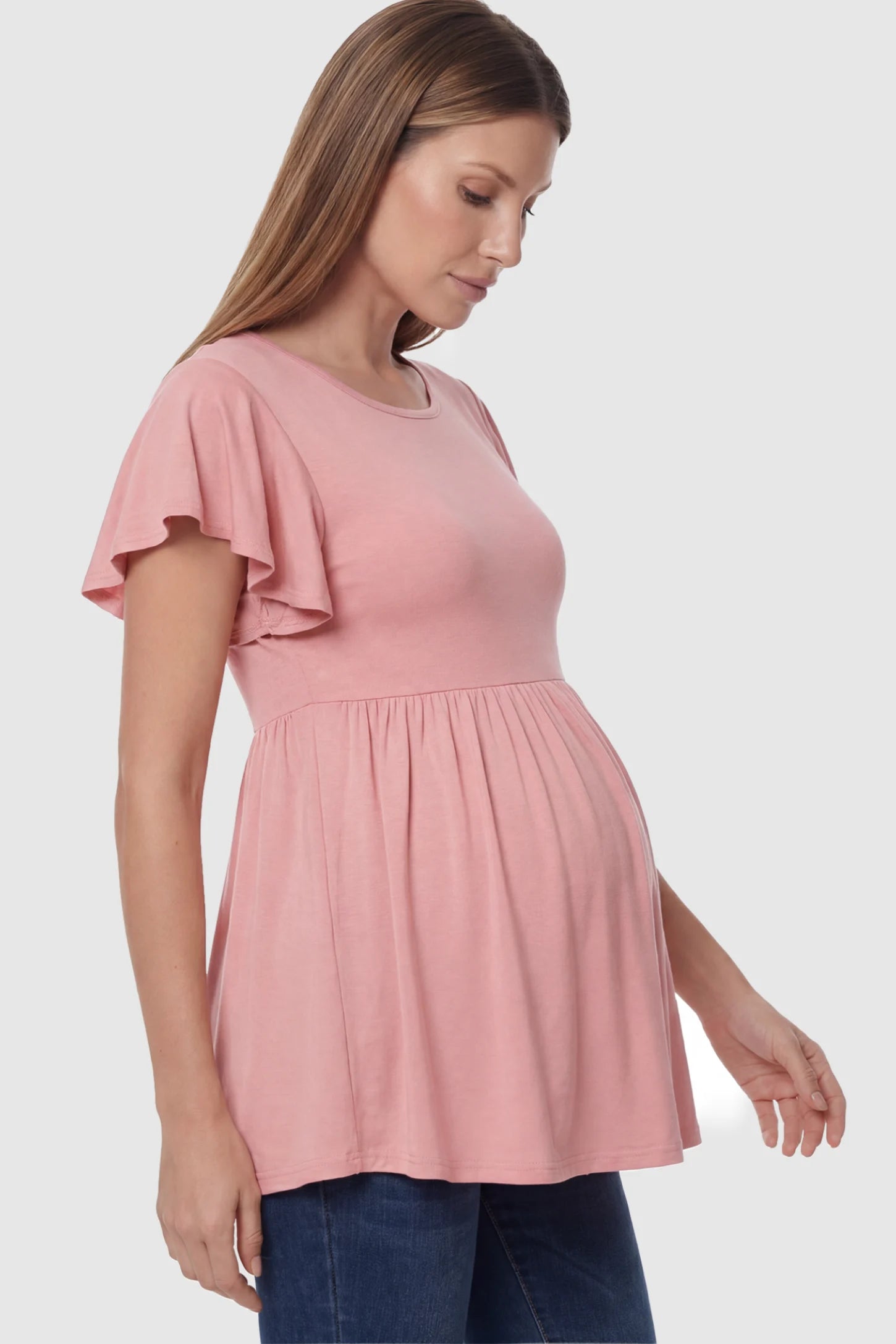 Solid Ruffled-Sleeve Flowy Maternity Top Solid Ruffled-Sleeve Flowy Maternity Top in Pink featuring a pleated empire waist on a pregnant model in side view.