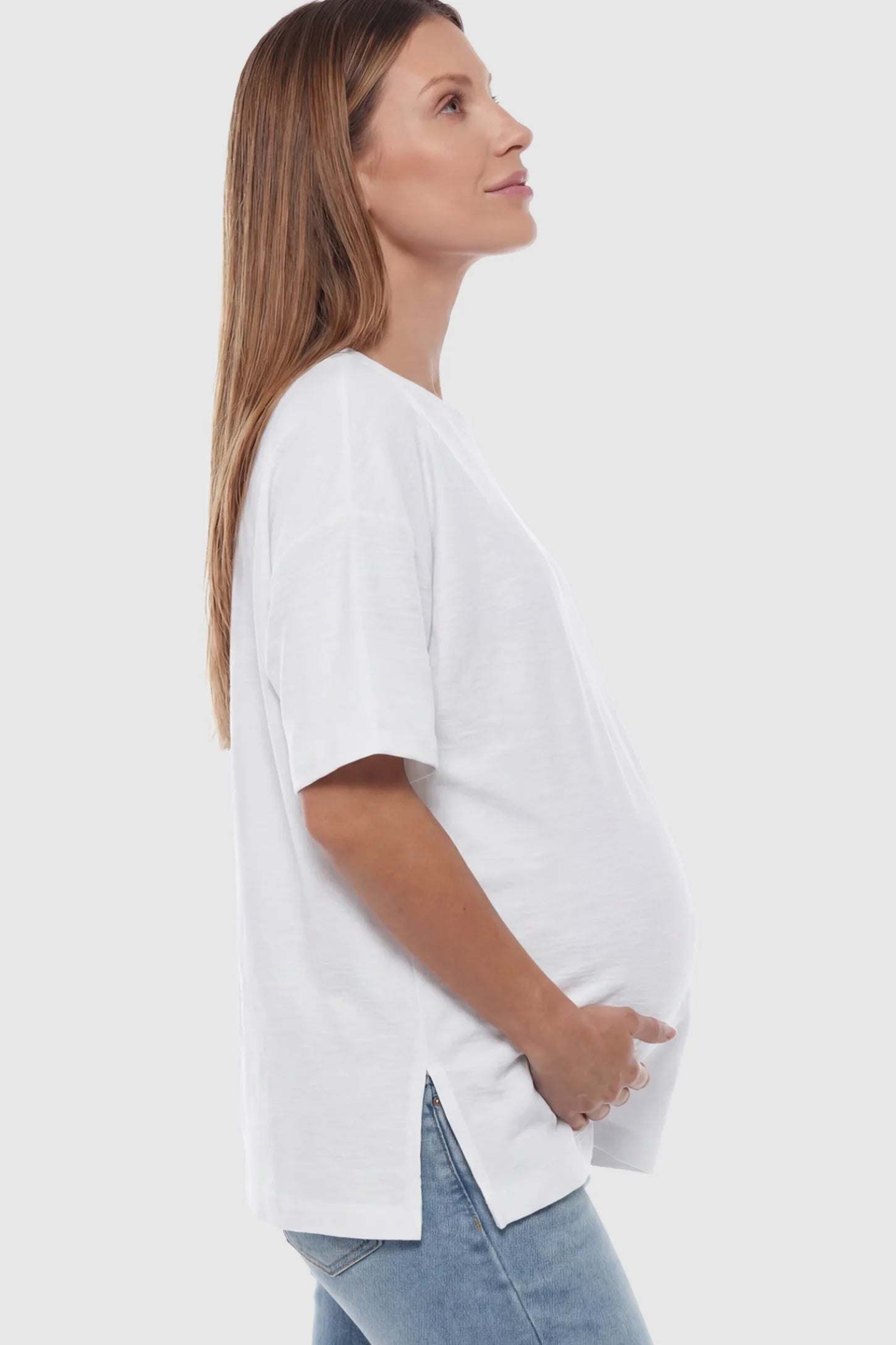 Oversized Short Sleeve Maternity T-Shirt Textured Oversized Short Sleeve Maternity T-Shirt in White featuring a side-slit hem and drop shoulders on a model.