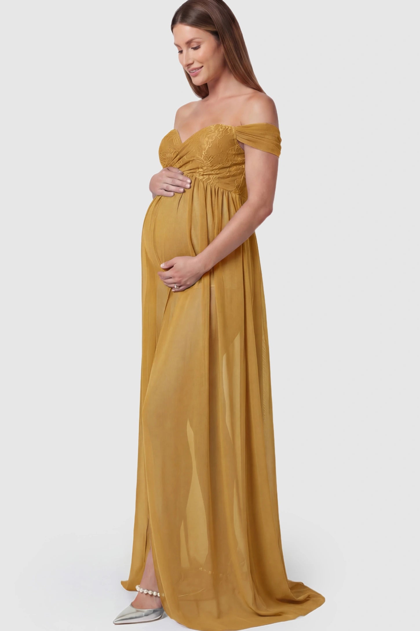 Lace Off Shoulder Slit Front Maternity Photoshoot Gown Lace Off Shoulder Slit Front Maternity Photoshoot Gown in apricot yellow featuring a flowy chiffon opening on a pregnant model.