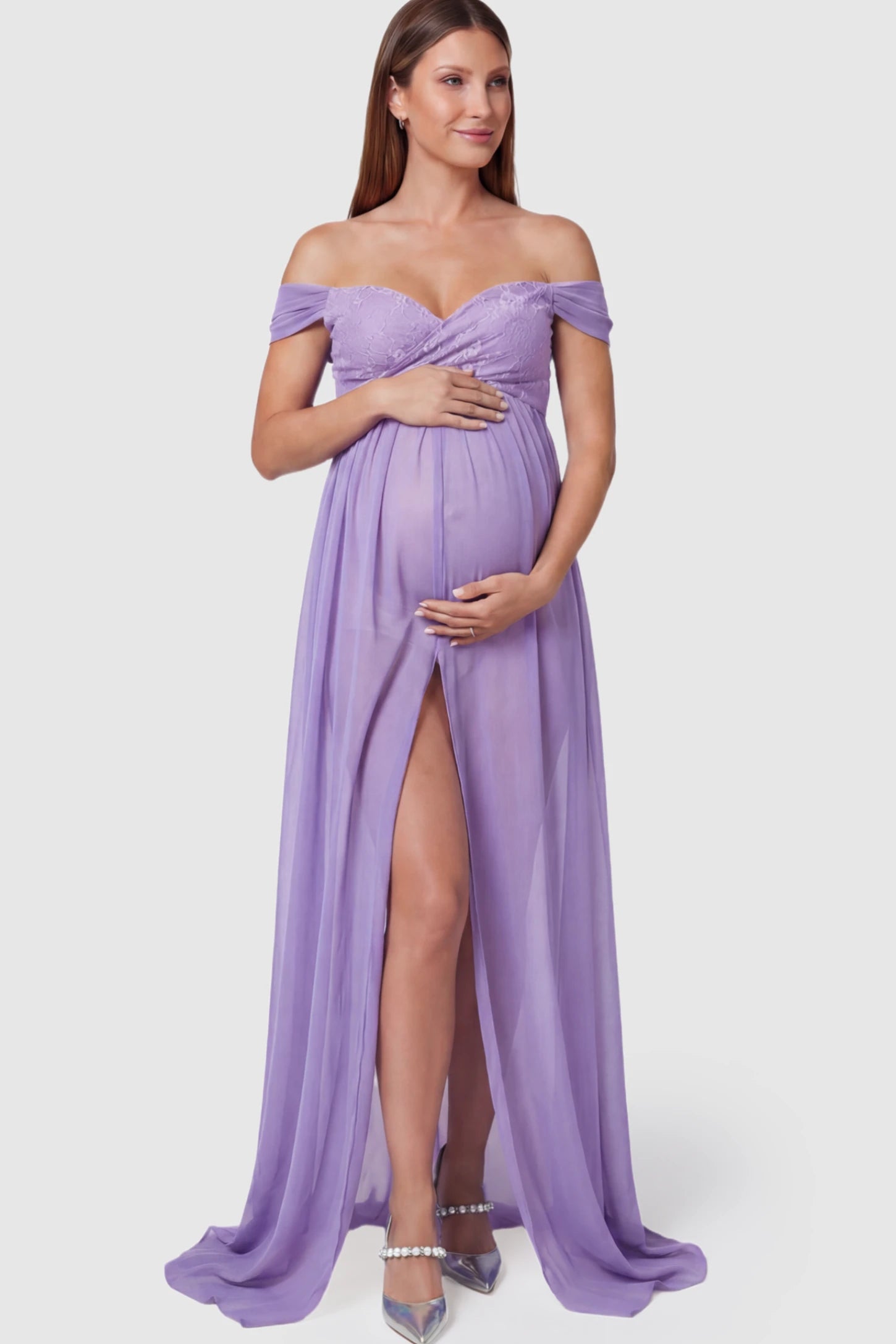 Lace Off Shoulder Slit Front Maternity Photoshoot Gown Lace Off Shoulder Slit Front Maternity Photoshoot Gown in light purple featuring a flowy chiffon opening on a pregnant model.