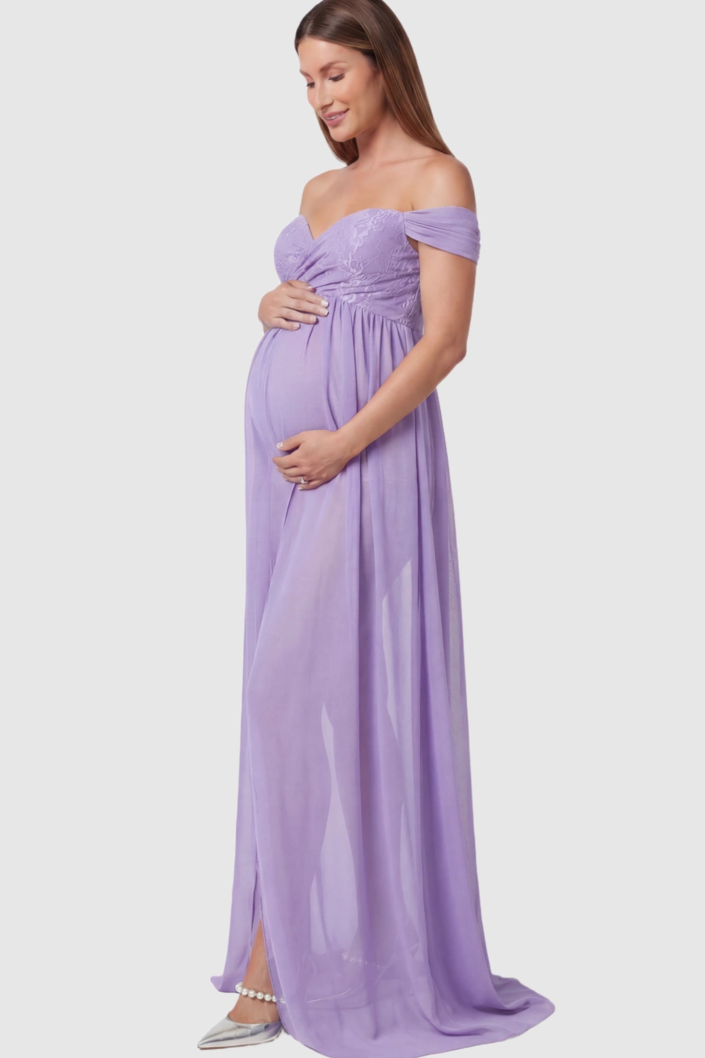 Lace Off Shoulder Slit Front Maternity Photoshoot Gown Lace Off Shoulder Slit Front Maternity Photoshoot Gown in light purple featuring a flowy chiffon opening on a pregnant model.