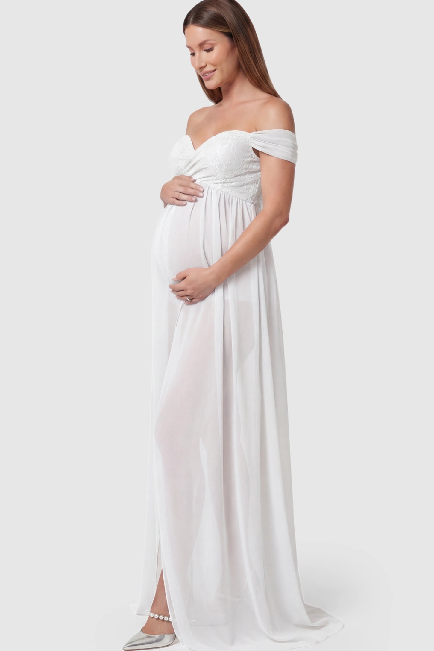 Lace Off Shoulder Slit Front Maternity Photoshoot Gown Lace Off Shoulder Slit Front Maternity Photoshoot Gown in white featuring a flowy chiffon opening on a pregnant model.