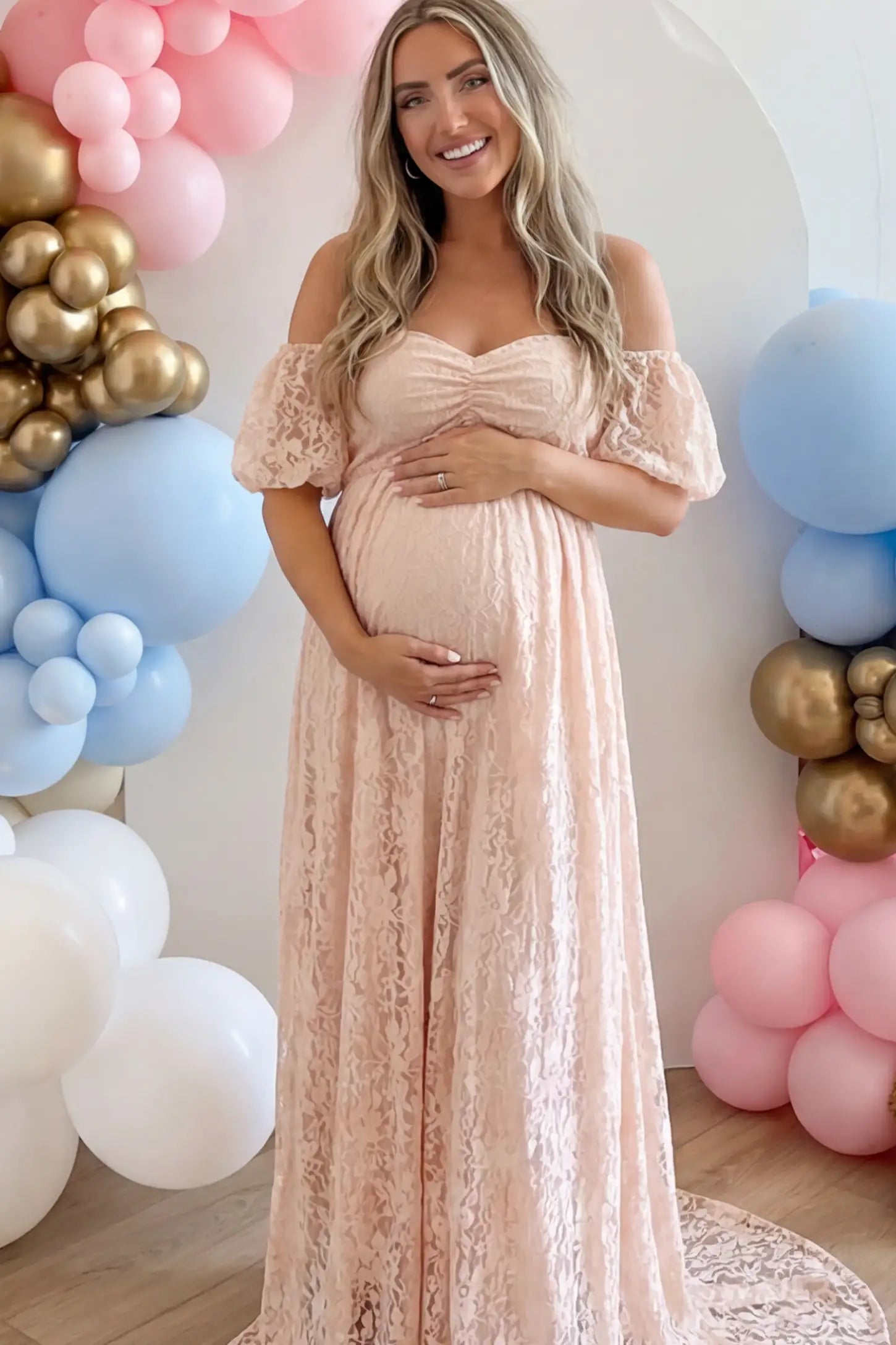 Floral Lace Off Shoulder Maternity Maxi Dress Floral Lace Off The Shoulder Maternity Maxi Dress featuring a ruched bust in Pink on a pregnant model.