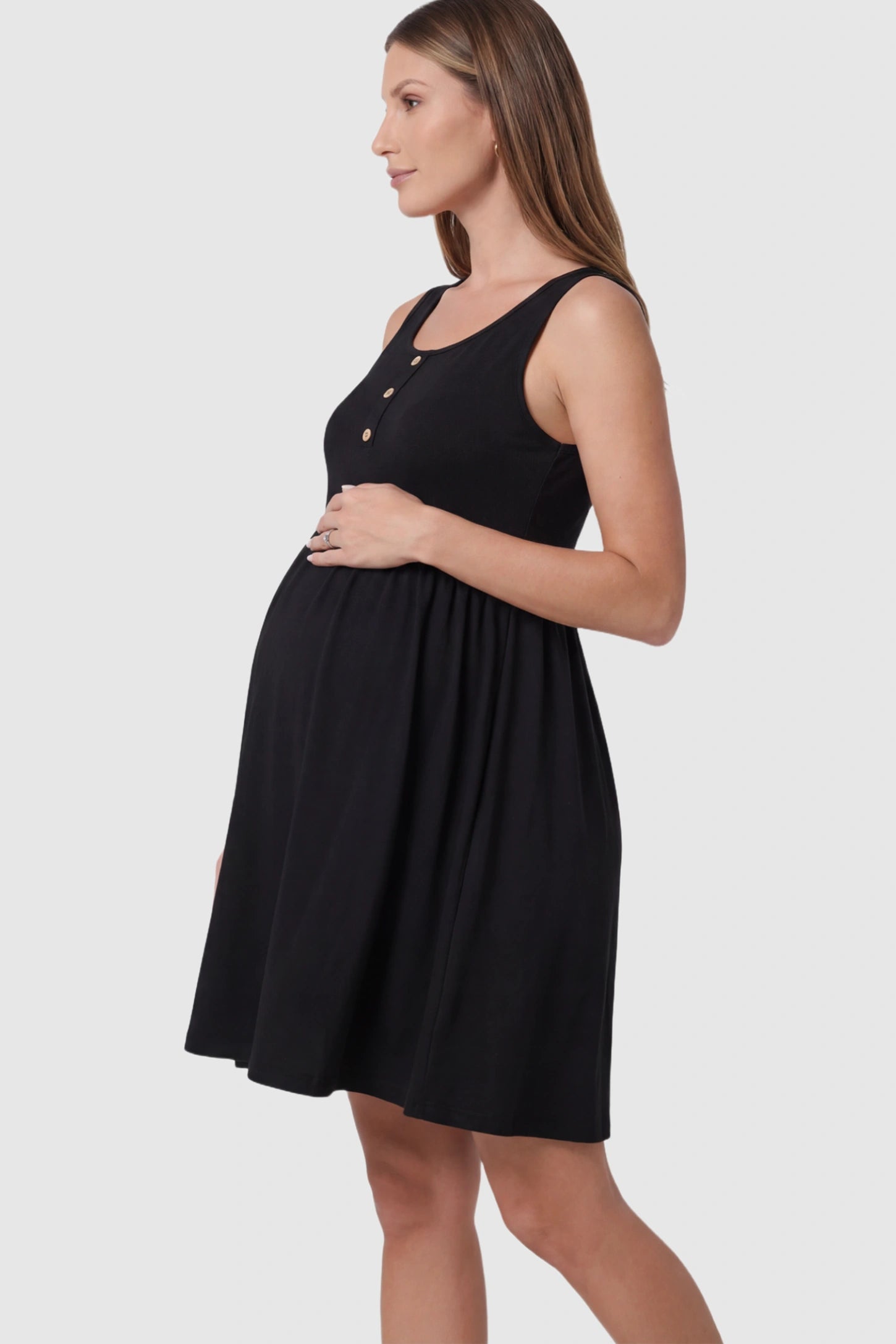 Button Accent Sleeveless Maternity Short Dress in Black featuring an empire waist on a pregnant model.