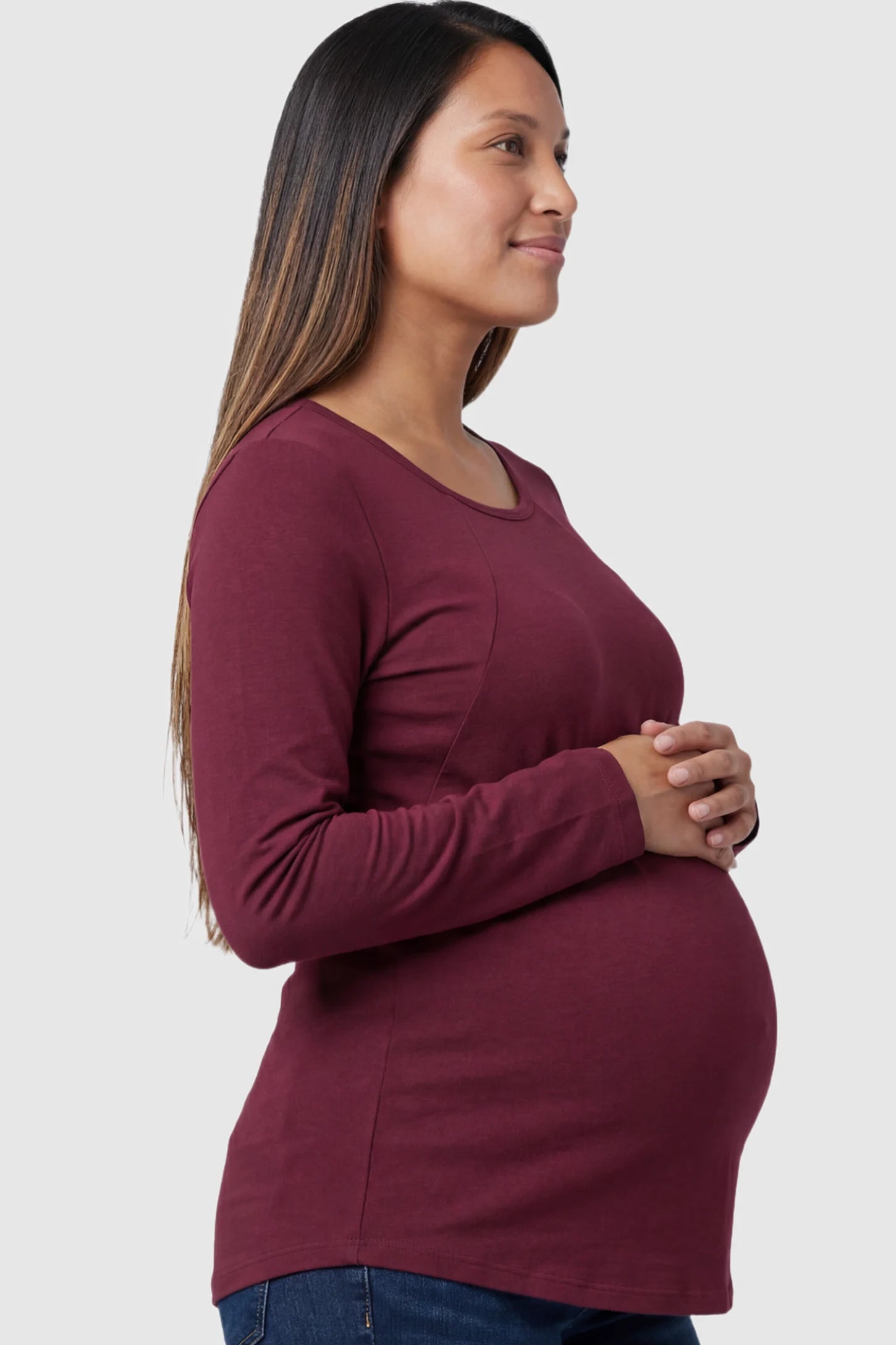 Solid Crew Neck Long Sleeve Maternity & Nursing Top in Wine Red featuring a discreet lift-up breastfeeding access on a model.