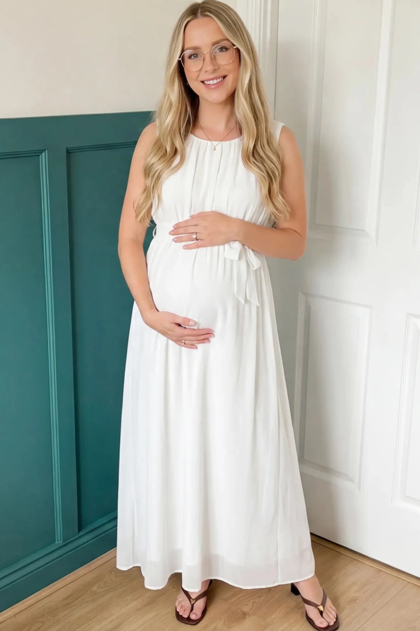 Empire Waist Tie-Front Sleeveless Maternity Maxi Dress Empire Waist Tie-Front Sleeveless Maternity Maxi Dress in White featuring a tie front and empire waist on a pregnant model.