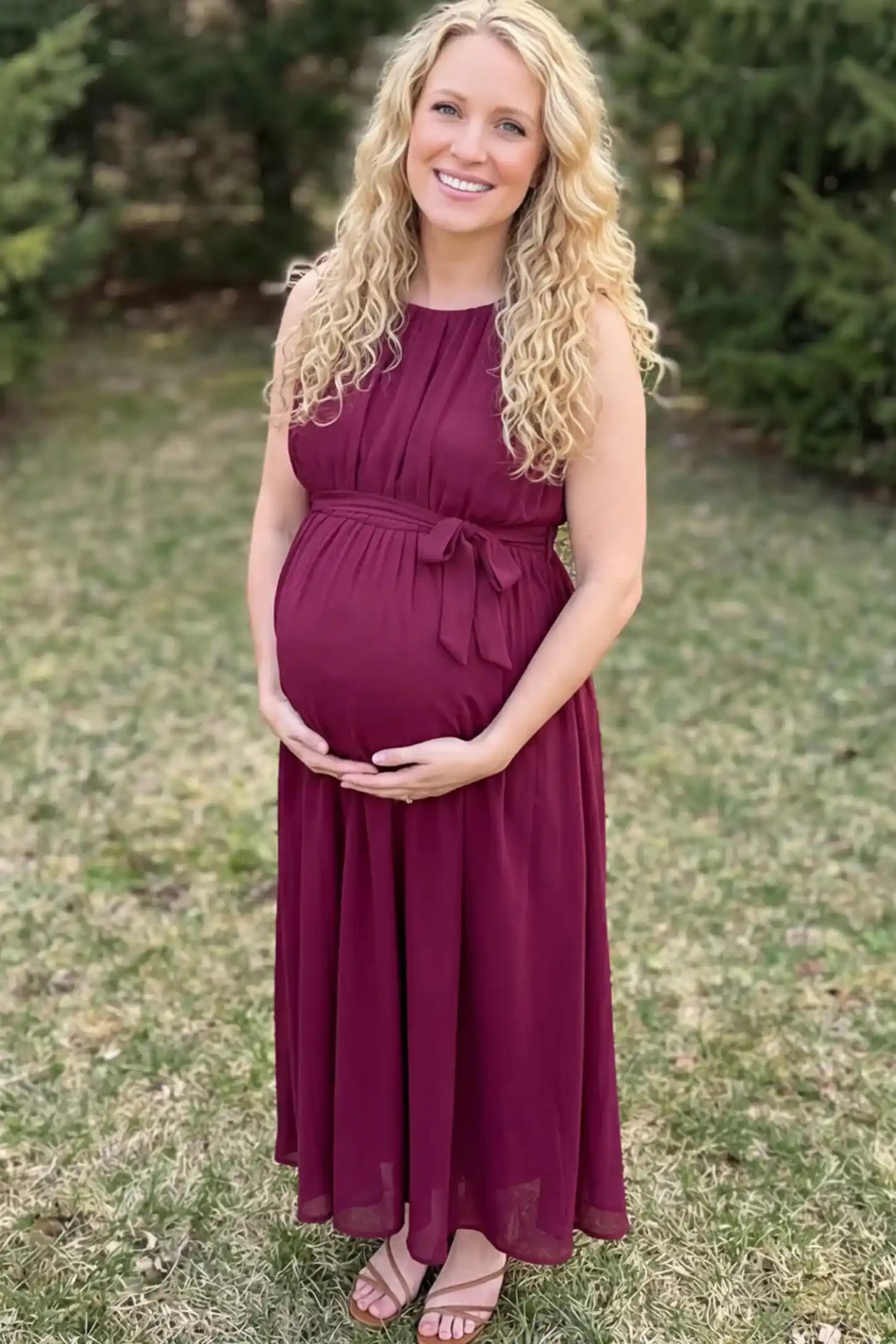 Empire Waist Tie-Front Sleeveless Maternity Maxi Dress Empire Waist Tie-Front Sleeveless Maternity Maxi Dress in Wine Red featuring a tie front and empire waist on a pregnant model.