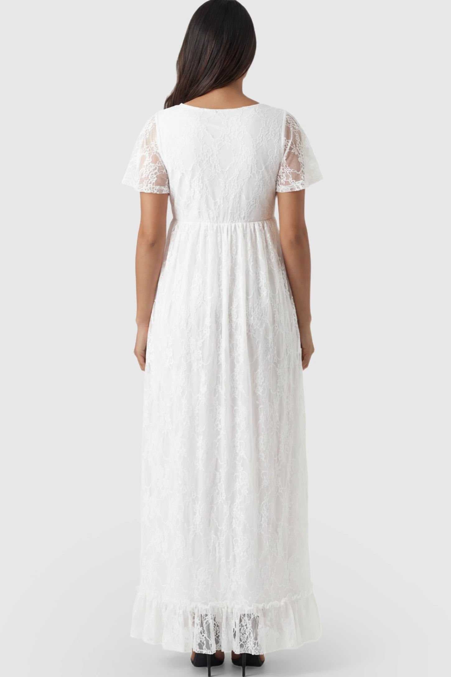 Floral Lace Flutter Sleeve Maternity Maxi Dress Floral Lace Flutter Sleeve Maxi Maternity Dress in White featuring delicate lace and an empire waist on a pregnant model.